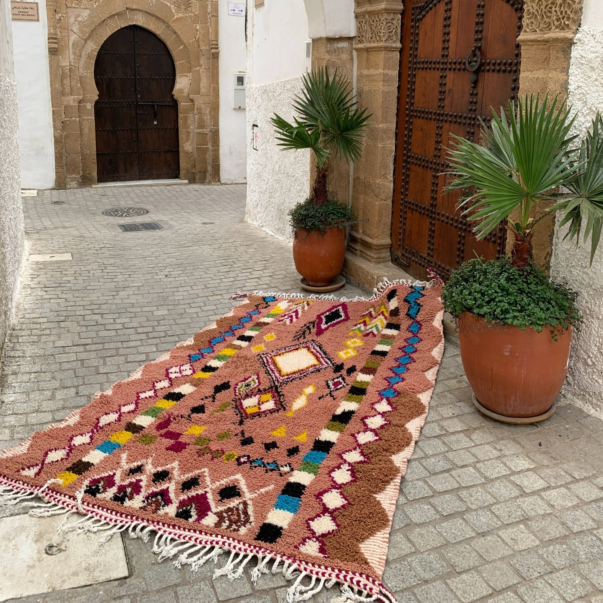 Artisan Treasures pink Moroccan rug with colorful Berber diamond tribal designs and textured sides, handwoven by Berber artisans.