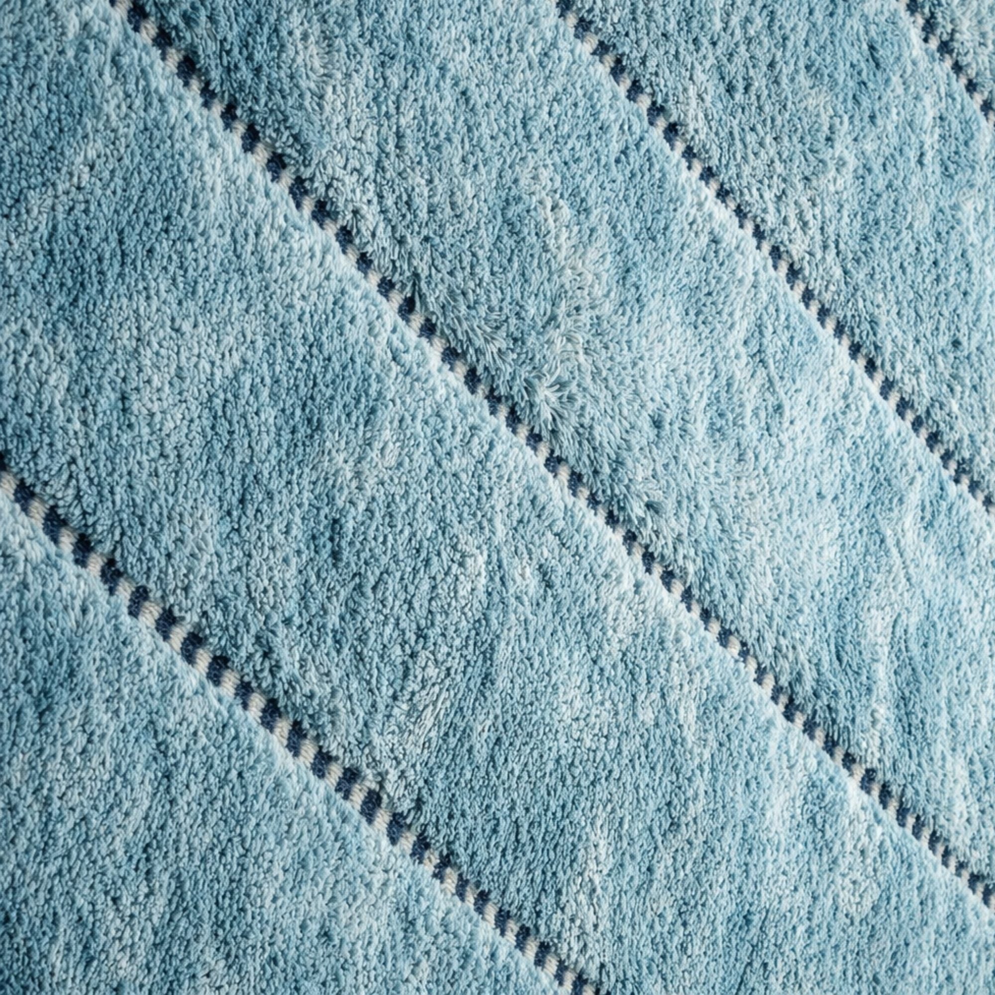 Brume No. 01 handmade Moroccan wool rug in powder blue with hand-finished fringe and woven construction