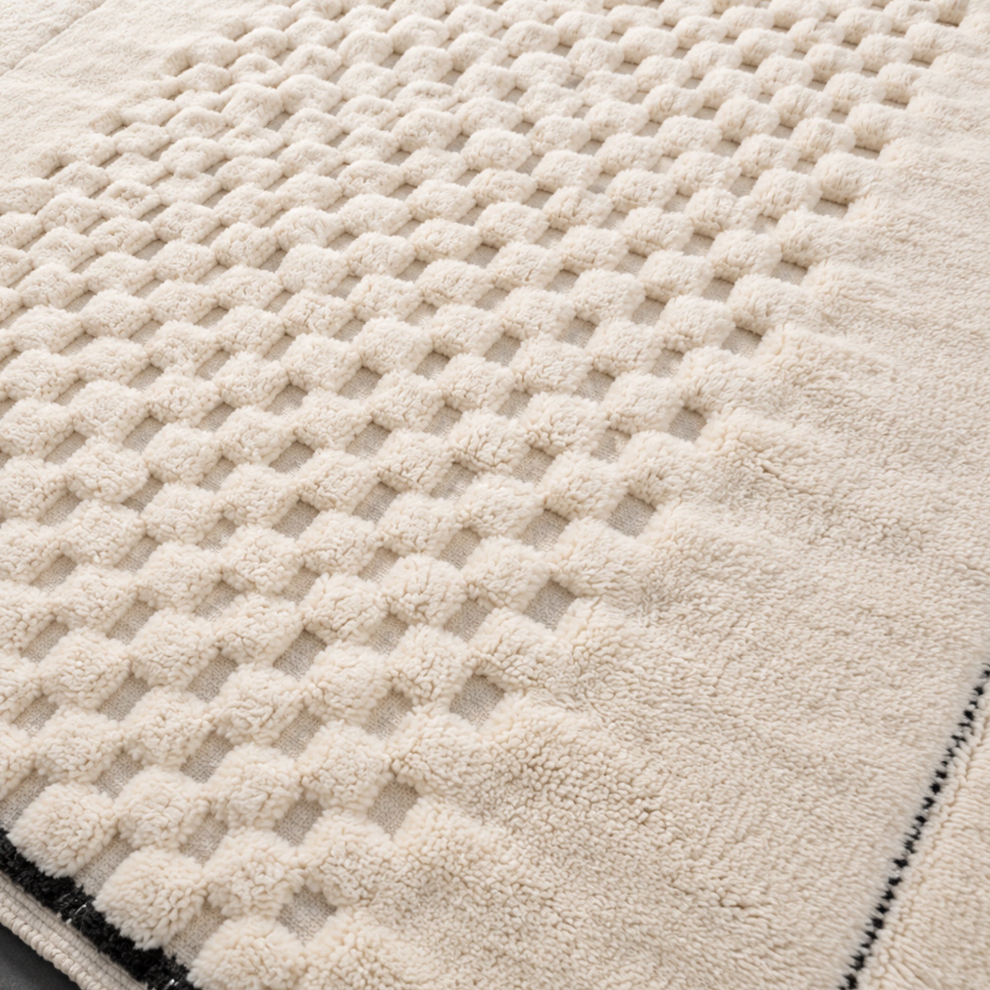 Close-up of Interval Moroccan wool rug showing sculpted checker weave texture in ivory wool.