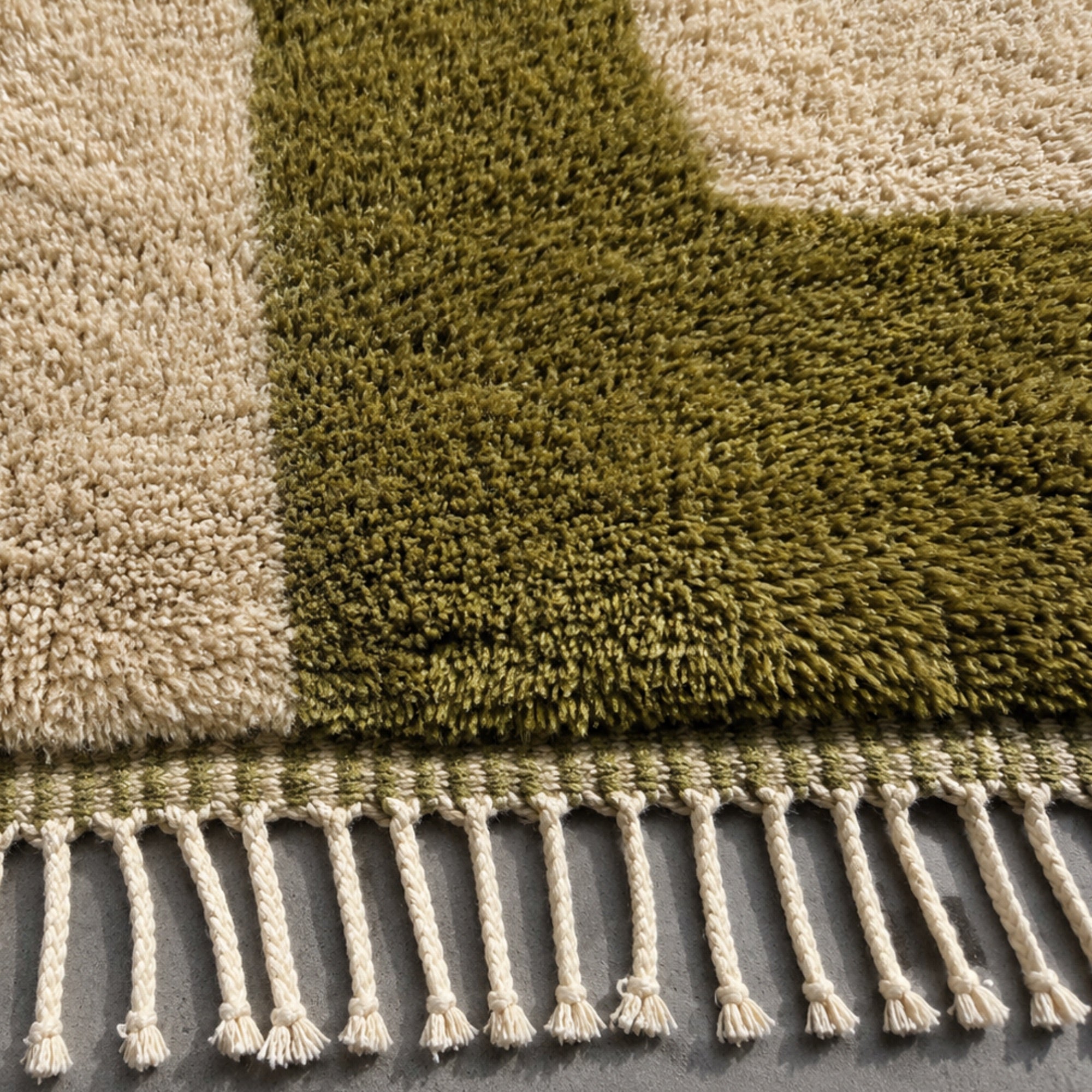 Close-up of Relic Moroccan wool rug edge showing olive and beige color blocking and fringe weave.