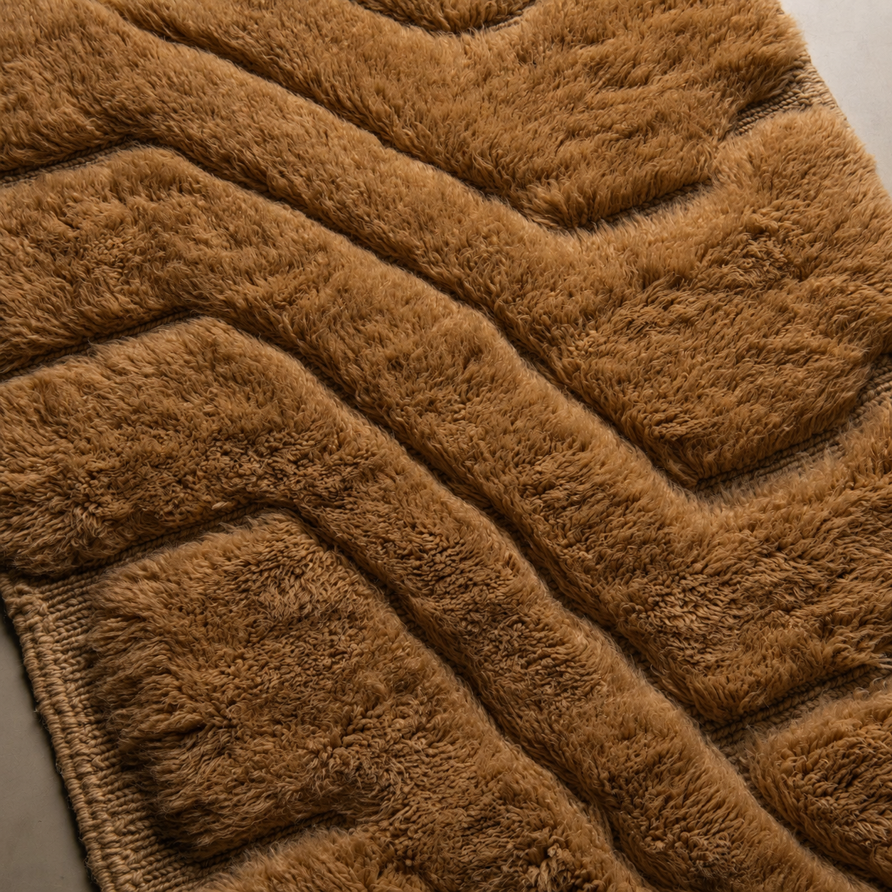 Close-up of Relief No. 01 Moroccan wool runner showcasing its sculptural high-pile texture, carved relief lines, dimensional wool surface, and rich camel brown color with artisanal handmade character.