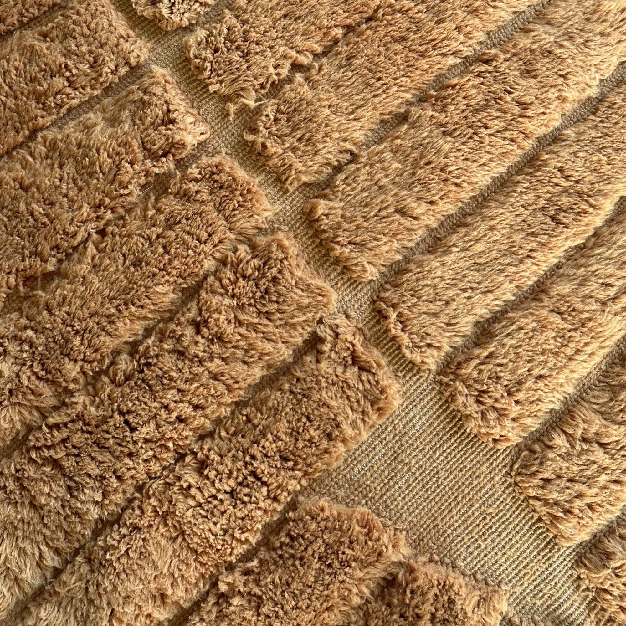 Close-up of Stratum No. 01 showcasing the handcrafted sculptural wool pile and woven recessed texture.