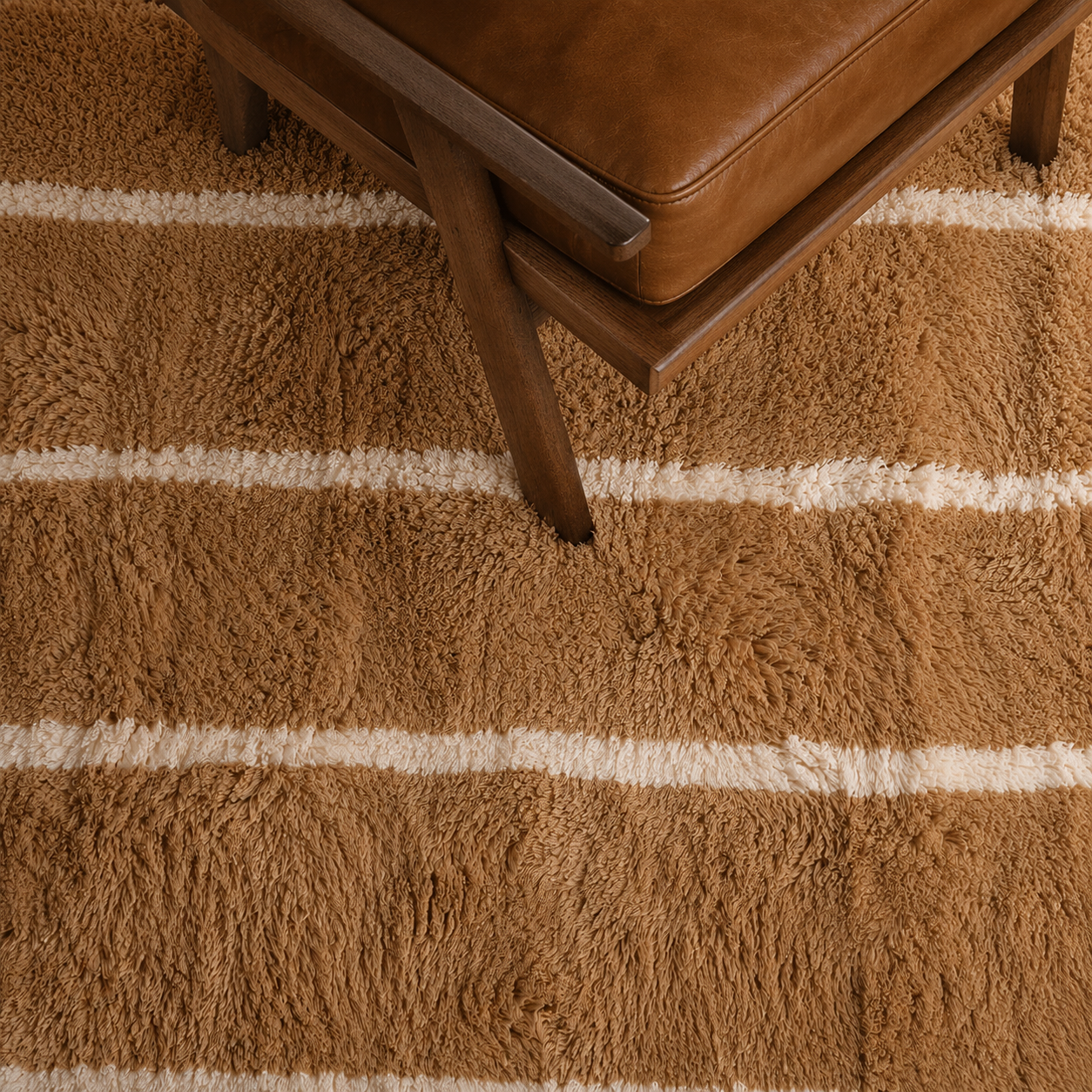 Detailed view of Veil No. 01 highlighting the plush high-pile wool texture, warm camel color, and handcrafted ivory striped design woven by Moroccan artisans.