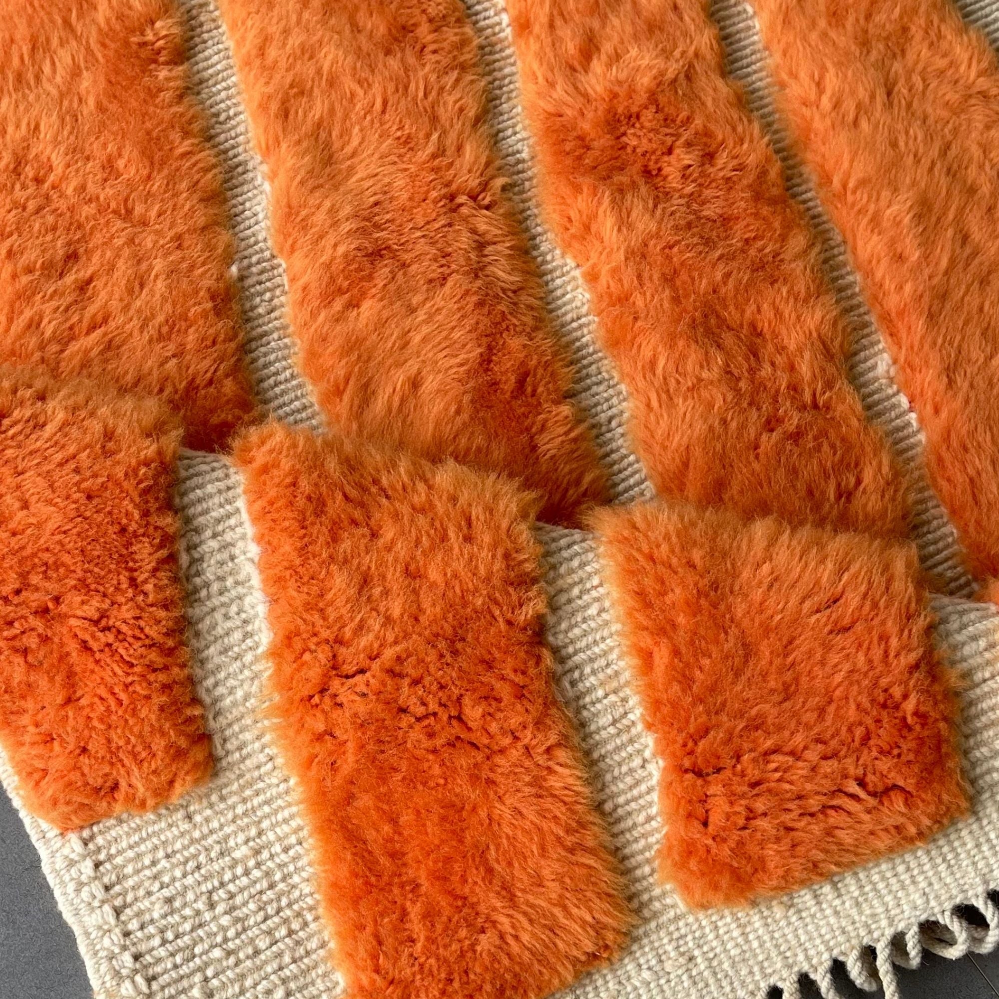 Detailed view of the sculptural raised wool pattern and woven natural wool base.