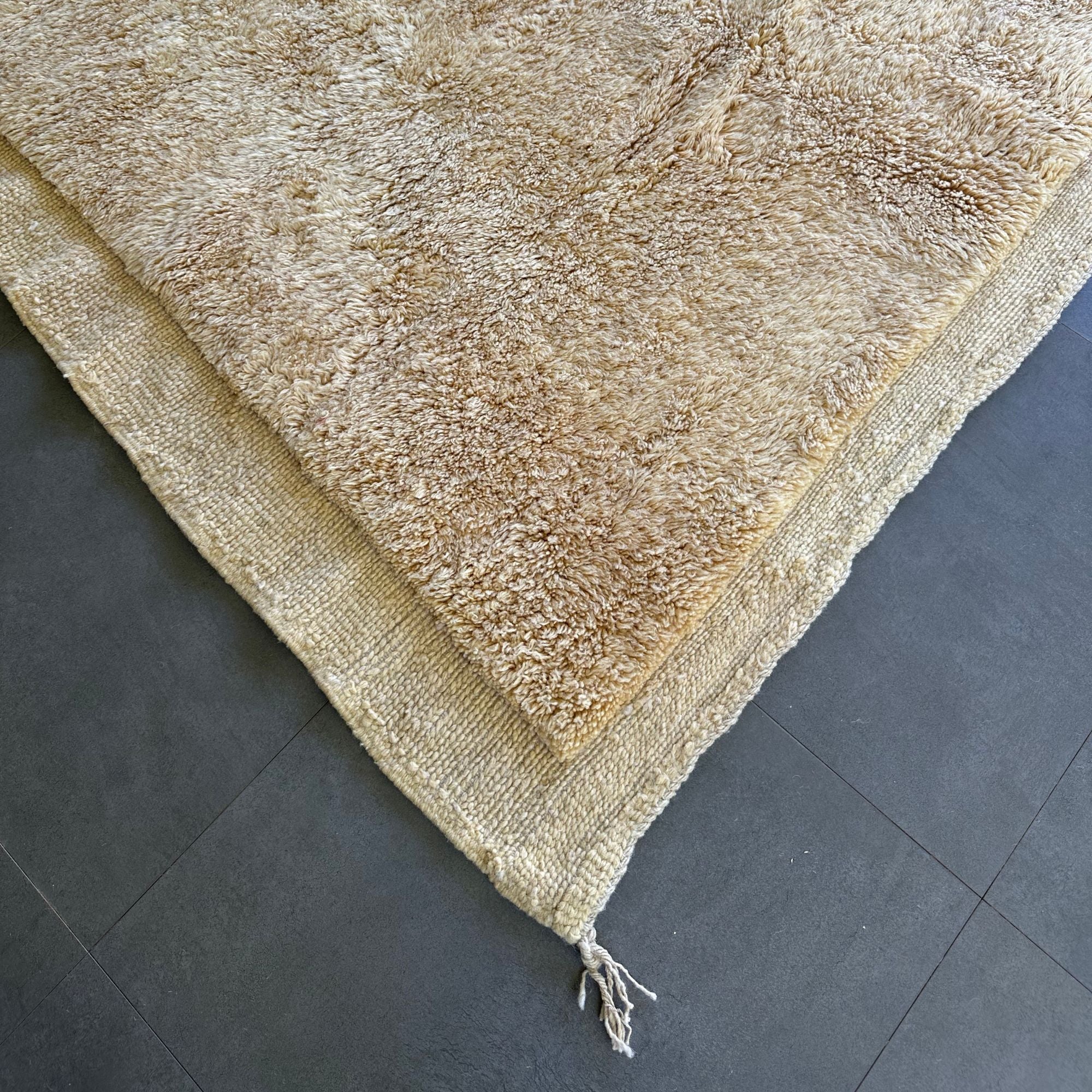 Ethereal Elegance handmade wool rug with an immaculate creme color, long pile in the center, and flat edges, handwoven by Berber artisans