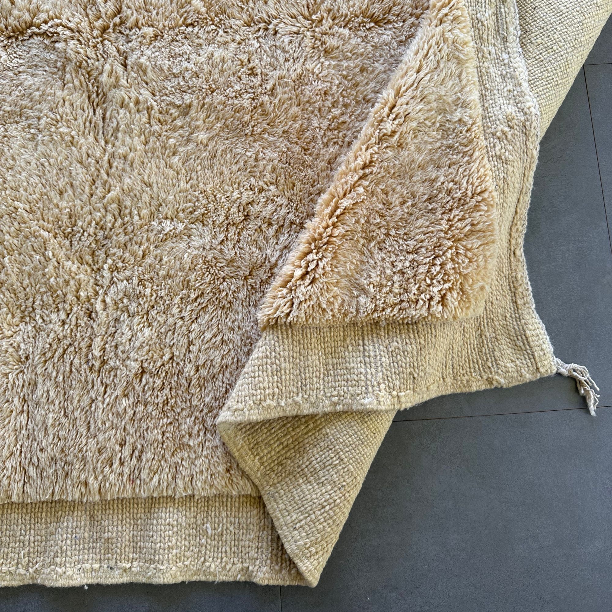 Ethereal Elegance handmade wool rug with an immaculate creme color, long pile in the center, and flat edges, handwoven by Berber artisans