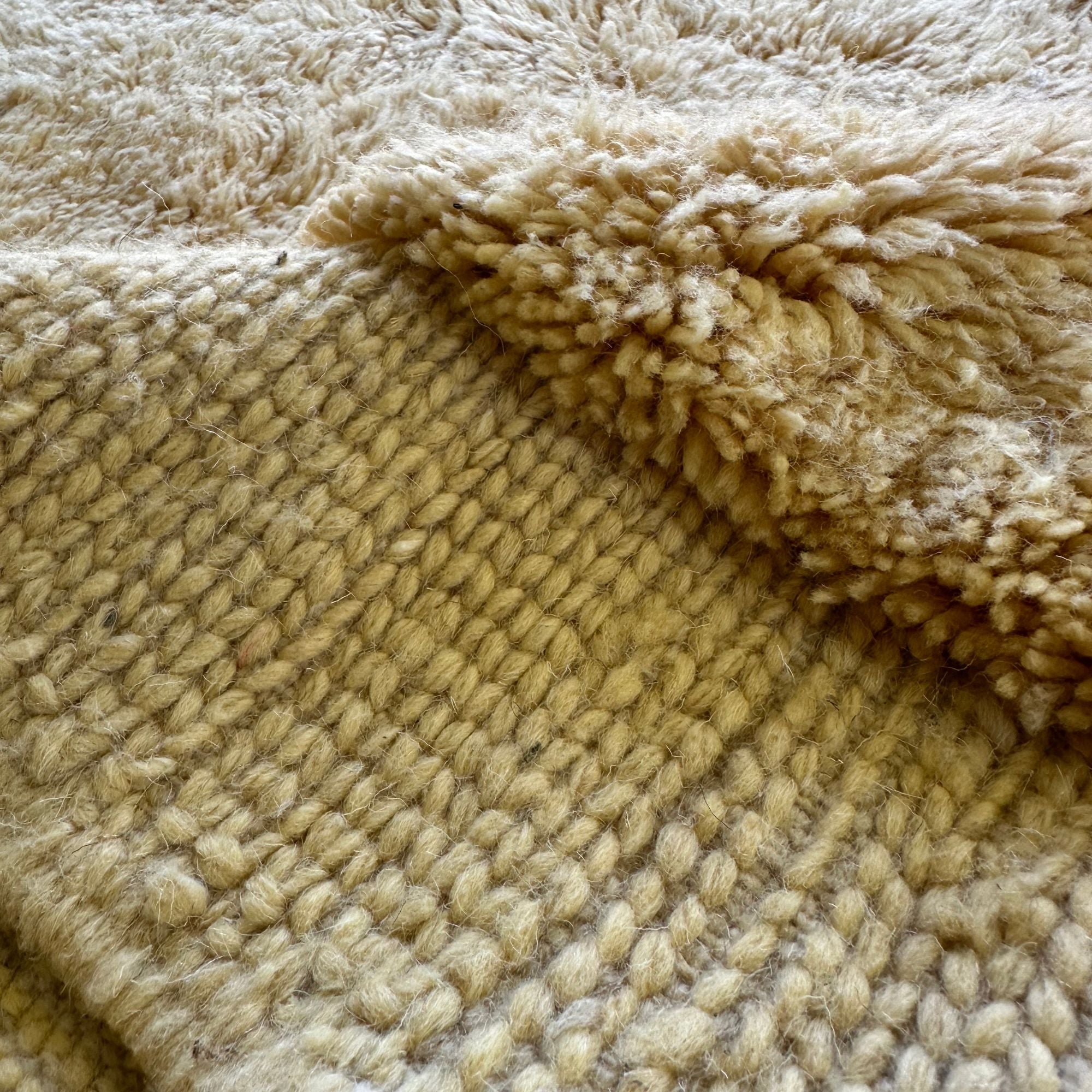 Ethereal Elegance handmade wool rug with an immaculate creme color, long pile in the center, and flat edges, handwoven by Berber artisans