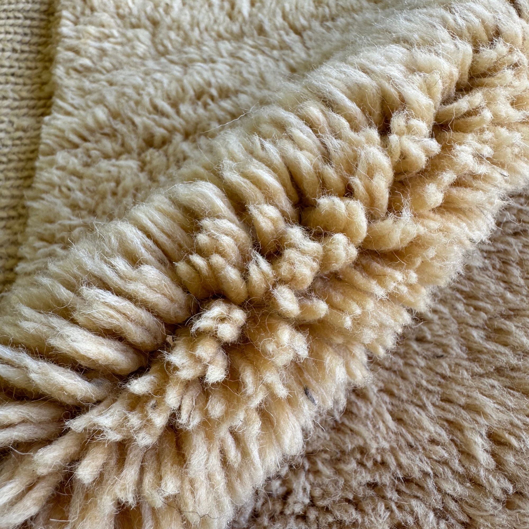 Ethereal Elegance handmade wool rug with an immaculate creme color, long pile in the center, and flat edges, handwoven by Berber artisans