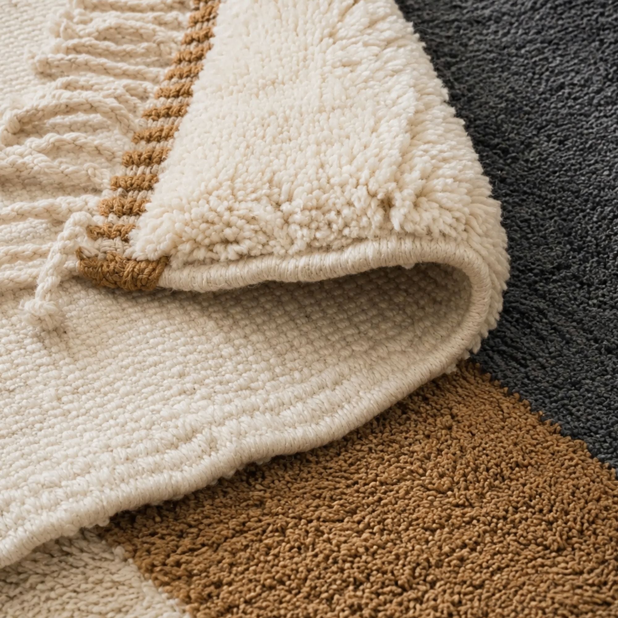 Handmade Moroccan wool rug edge and fringe detail in ivory camel and charcoal