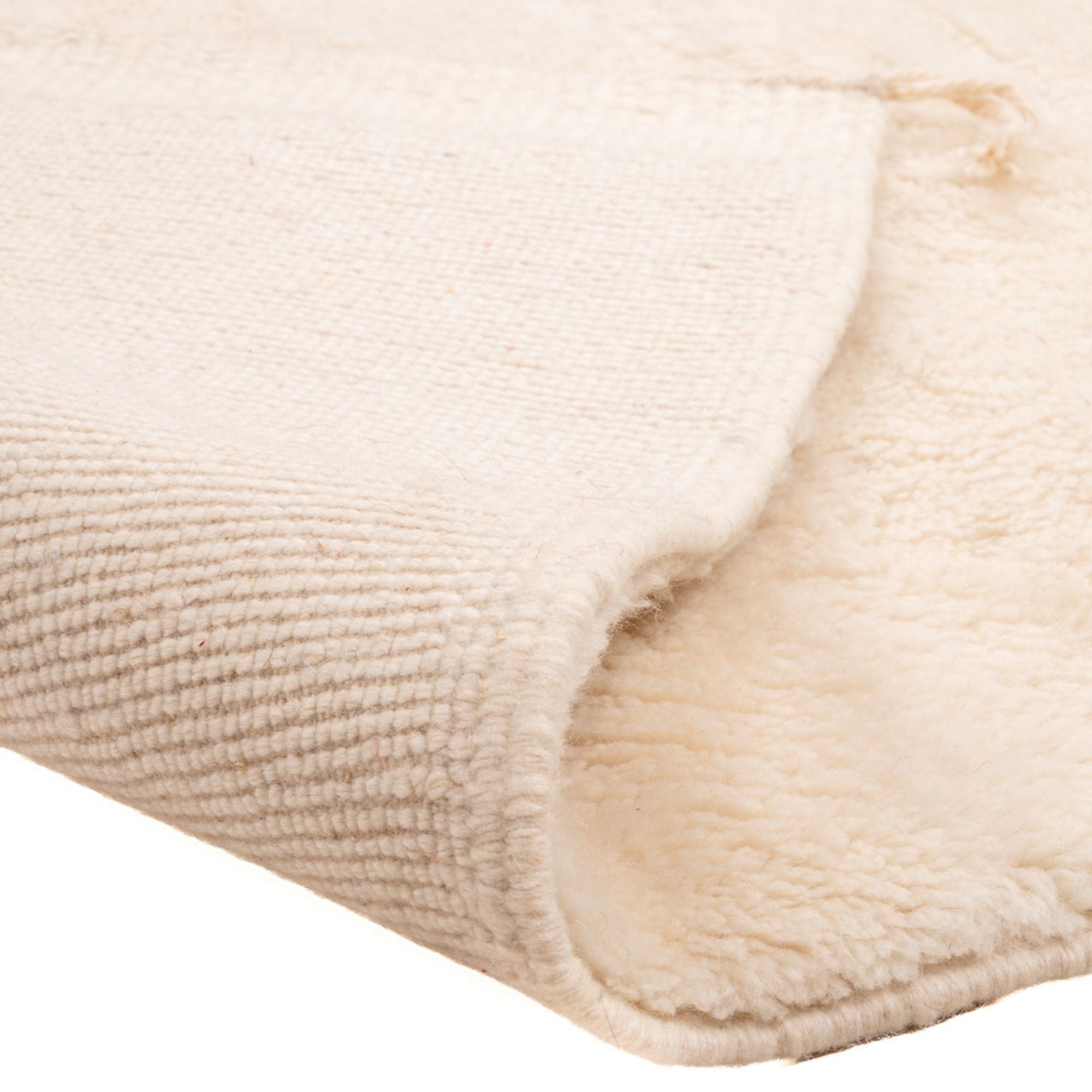 Handwoven Moroccan wool rug Épure folded showing dense weave backing and thick soft pile texture