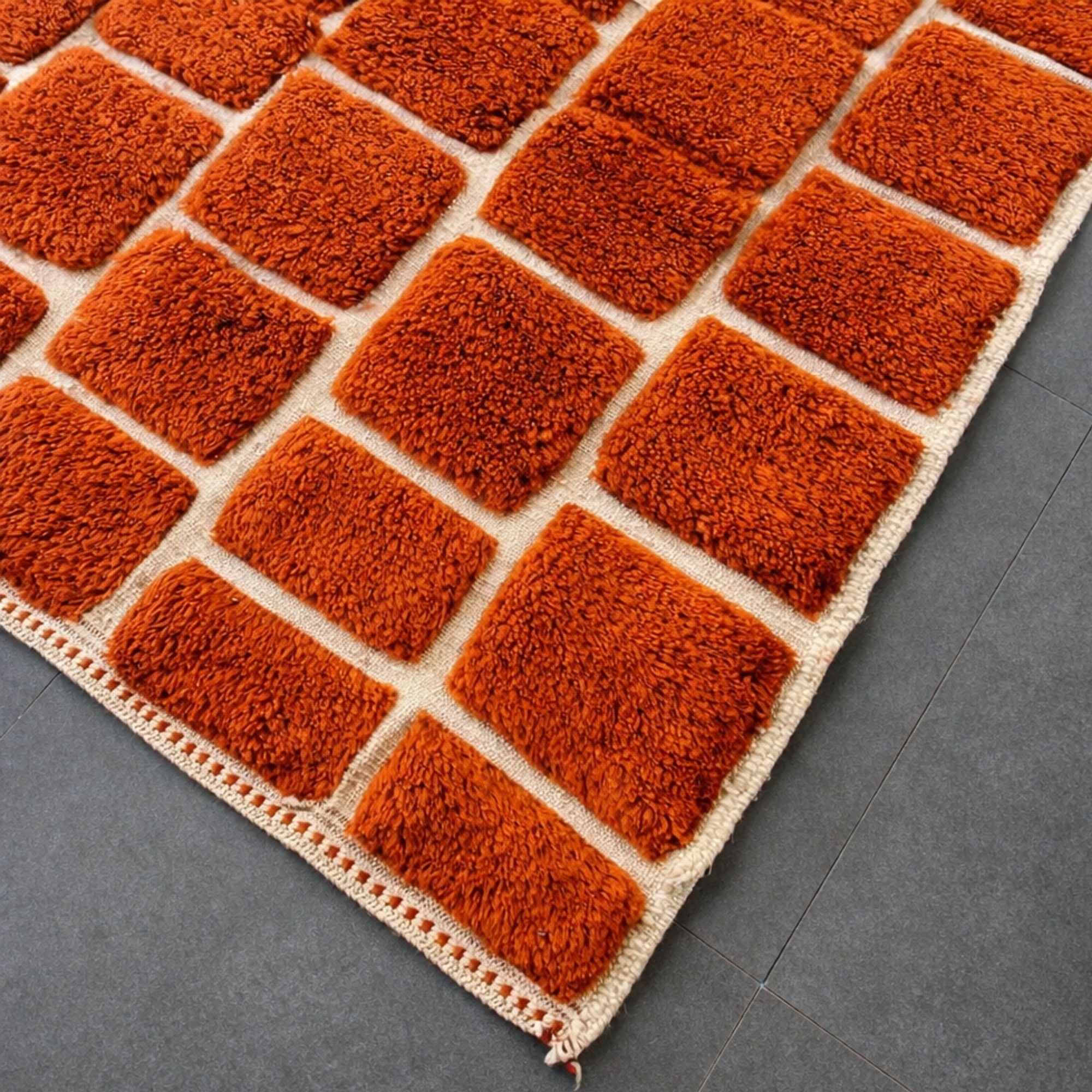 Handwoven Moroccan wool rug, Kiln design, corner detail showing raised block pattern on cream base.