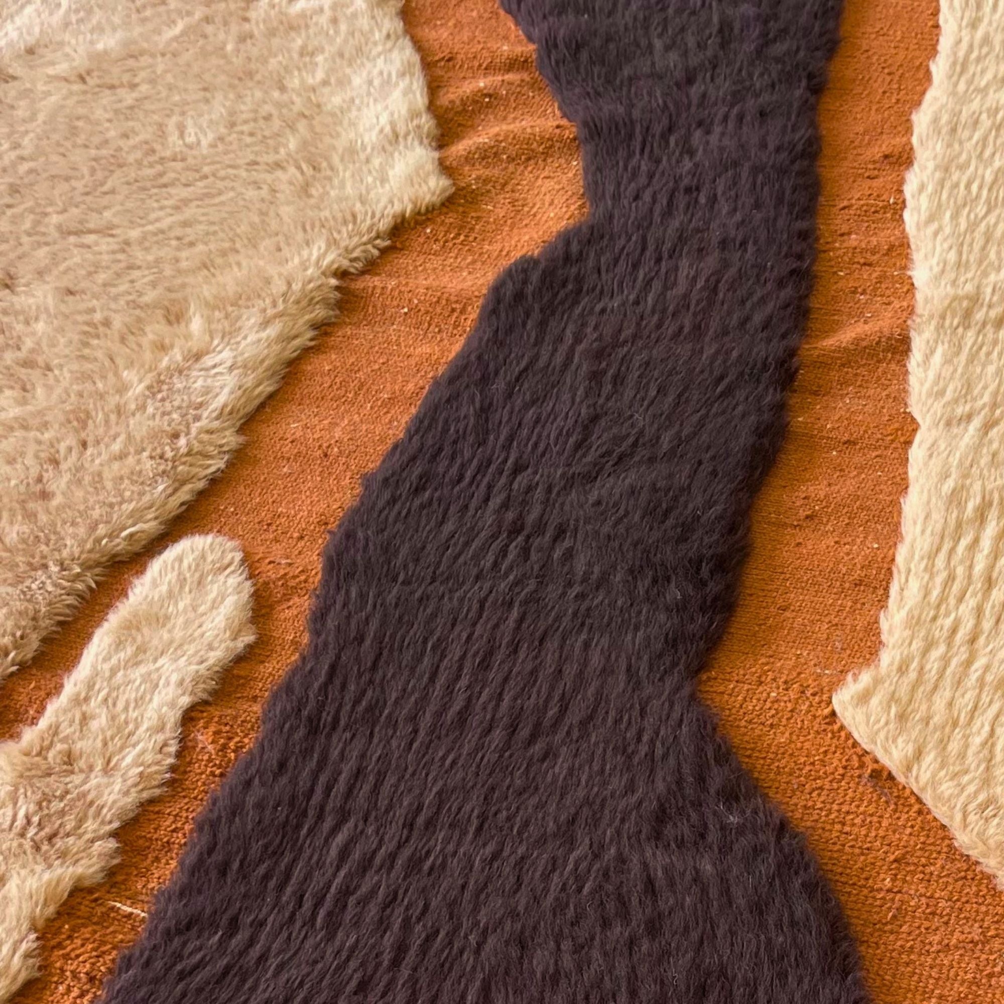 Handwoven Moroccan wool rug, Totem no. 01 design, close-up of cream, black, and rust color transitions in high-pile wool.