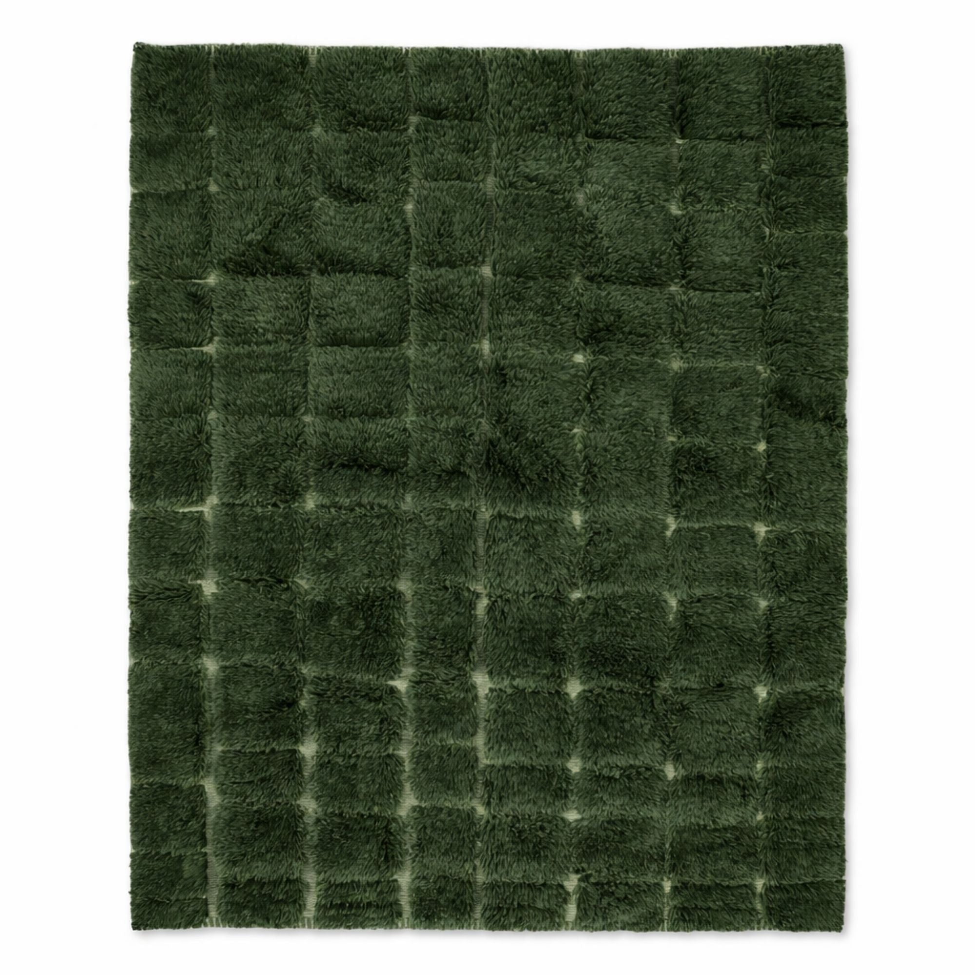Handwoven Moroccan wool rug, Understory design, deep forest green grid pattern, high-pile texture.