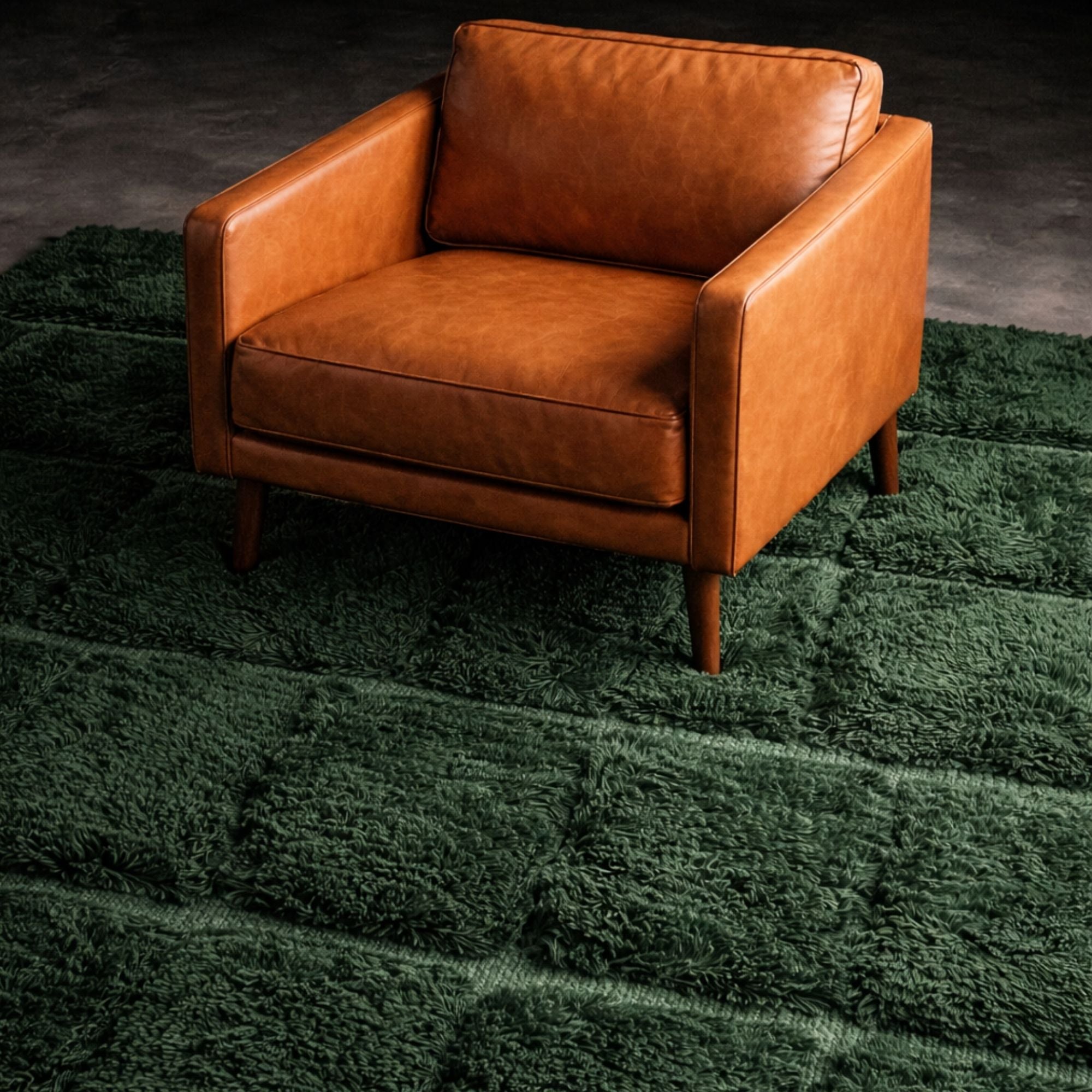 Handwoven Moroccan wool rug, Understory design, dense green pile styled beneath a leather armchair.