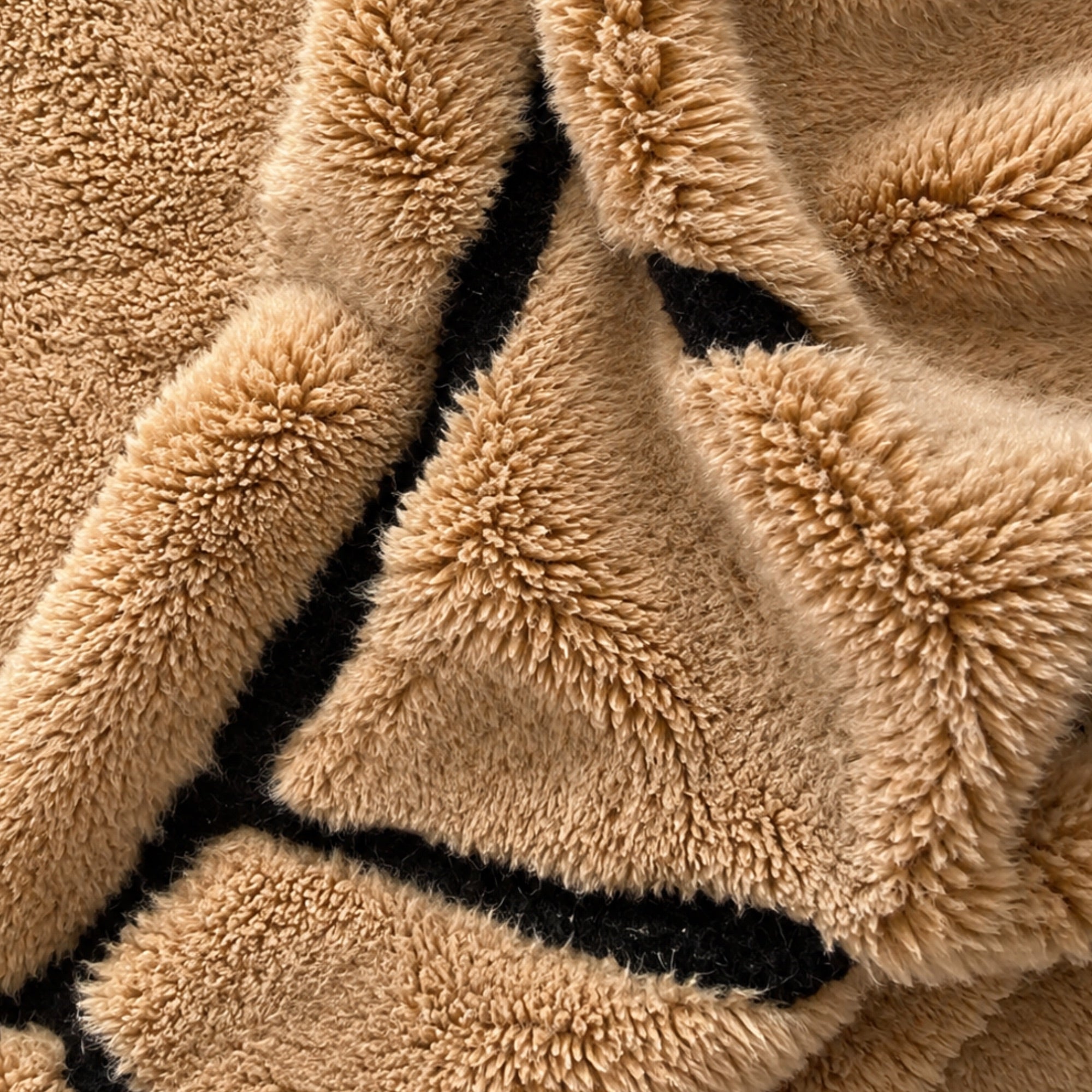 Handwoven Moroccan wool rug, Compass design, close-up of camel wool and black line detail.
