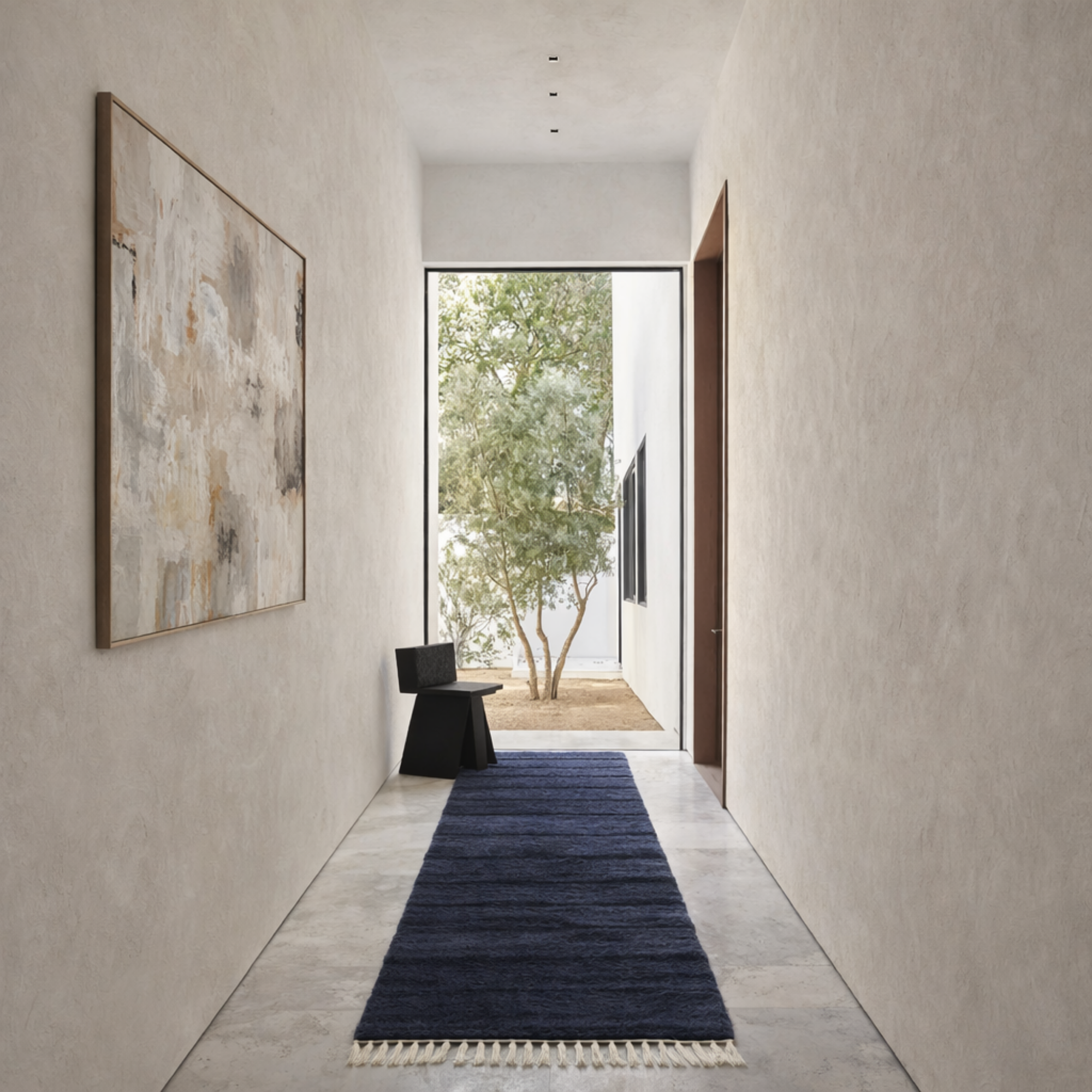 Linea Moroccan wool runner rug in deep navy styled in minimalist hallway with plaster walls and natural light.