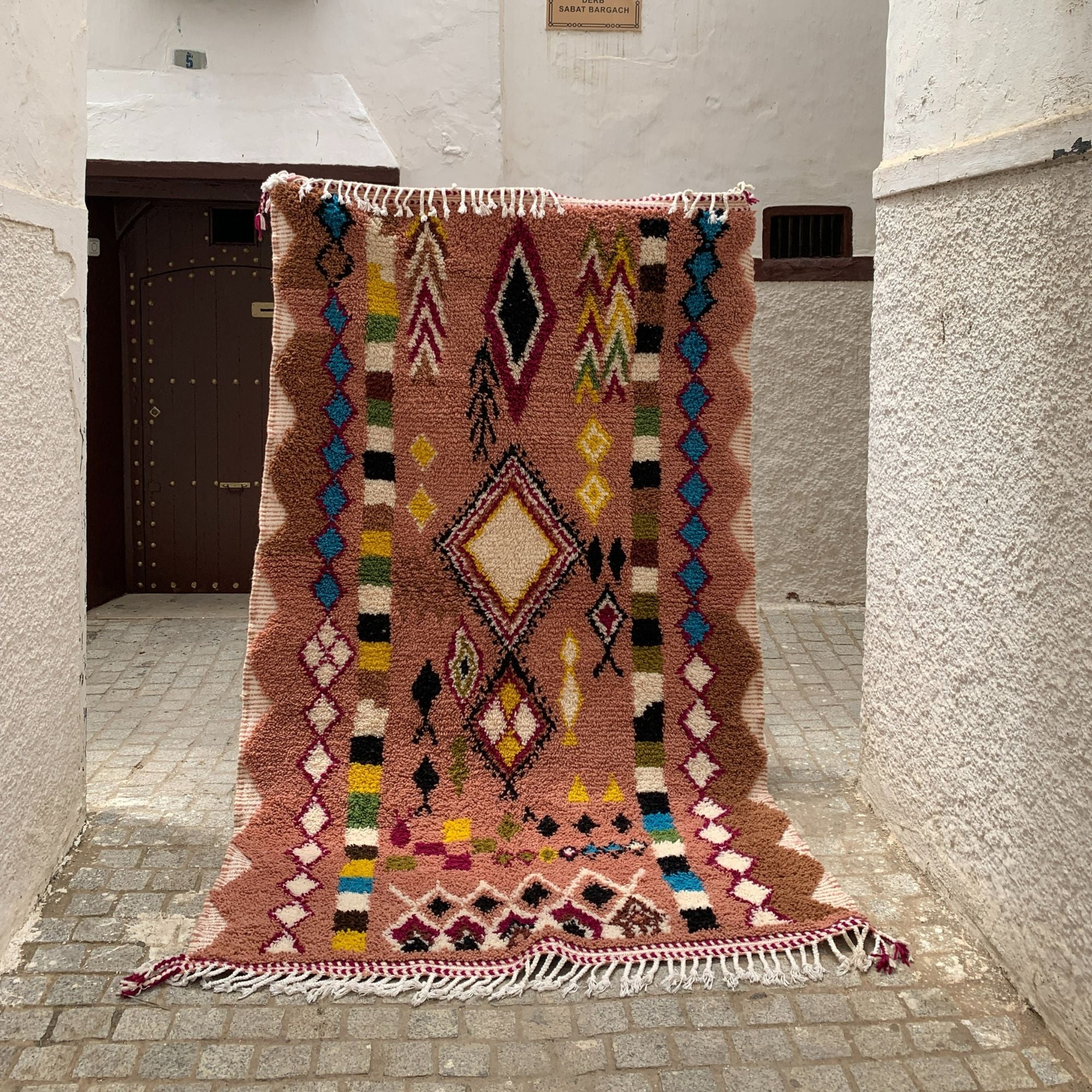 Artisan Treasures pink Moroccan rug with colorful Berber diamond tribal designs and textured sides, handwoven by Berber artisans.