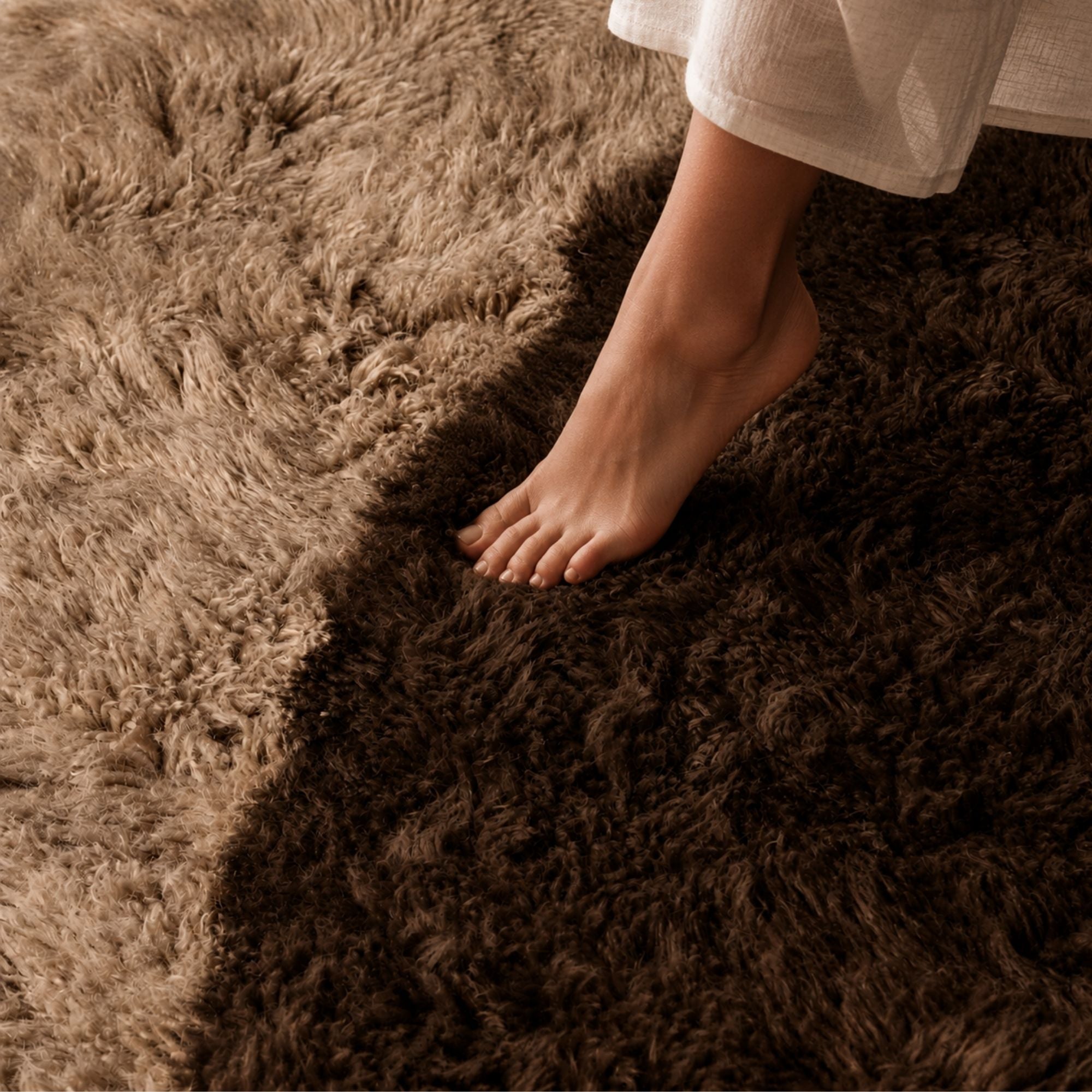 Bare foot stepping into the plush high-pile Moroccan wool rug, showcasing the softness, depth, and comfort of the handmade texture.