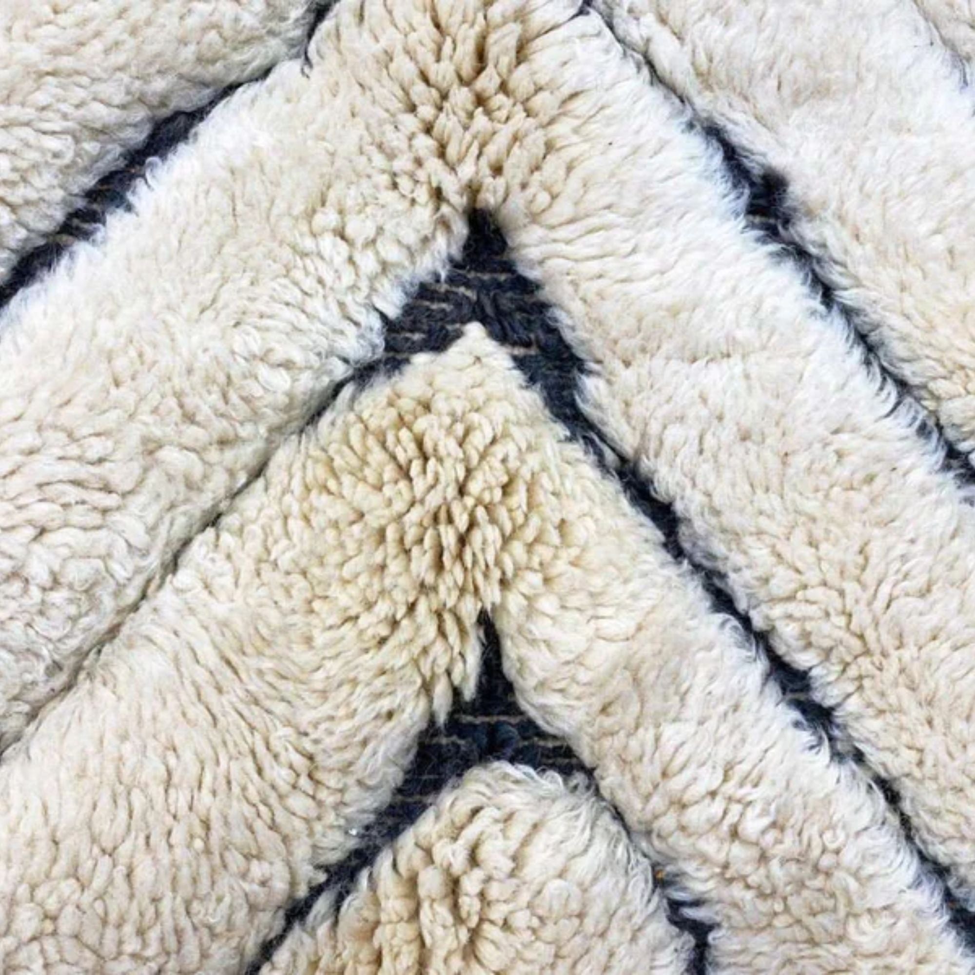 Berber Boulevards white Moroccan rug with a textured black diamond design, handwoven by Berber artisans.