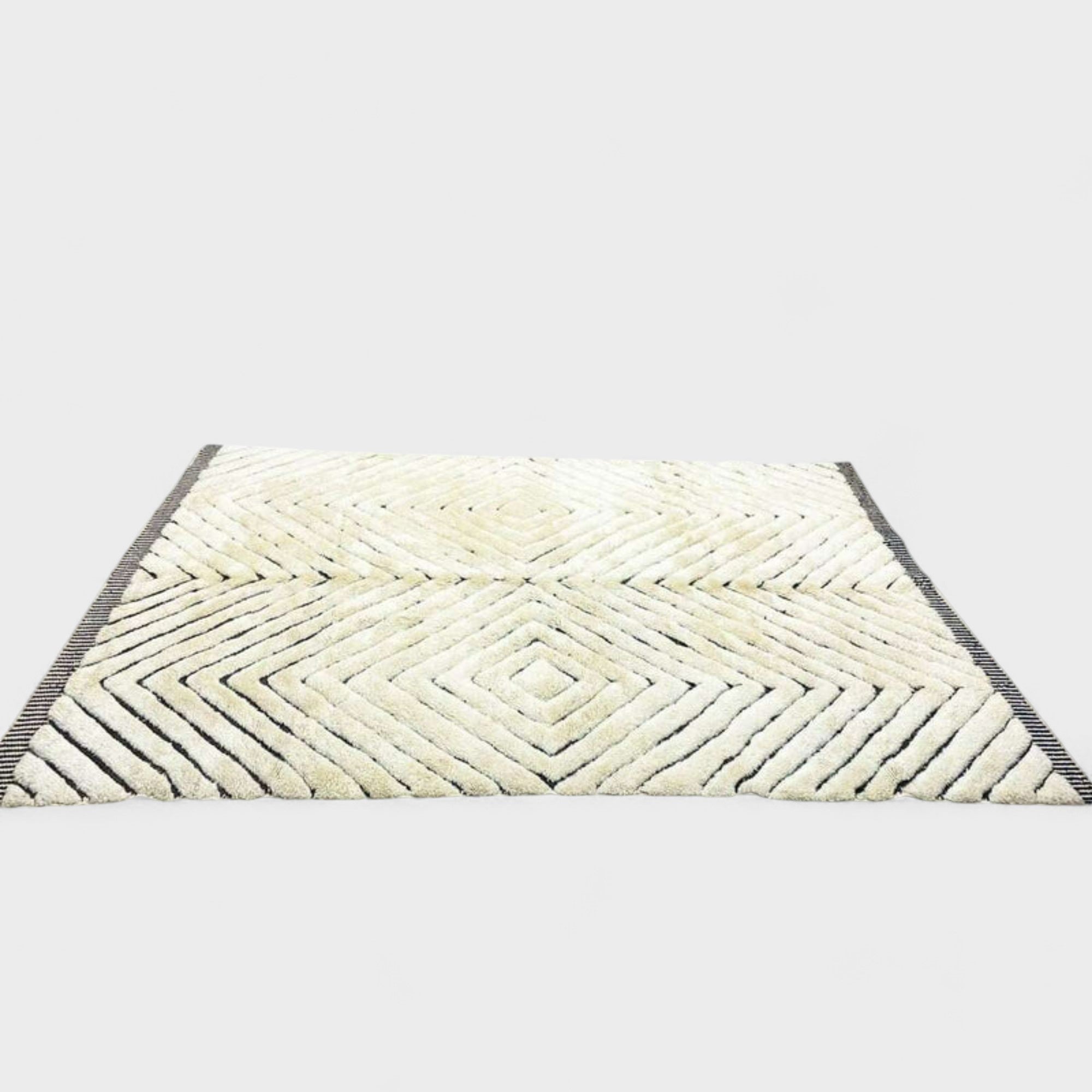 Berber Boulevards white Moroccan rug with a textured black diamond design, handwoven by Berber artisans.