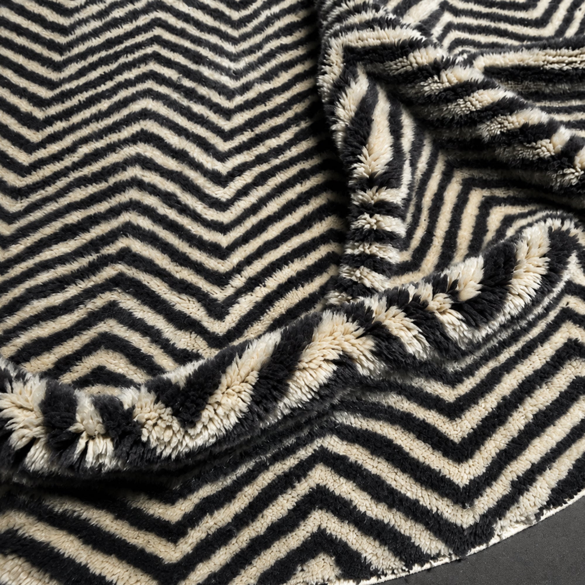  Close-up of Undertow Moroccan wool rug showing hand-drawn chevron weave and fringe edge detail.