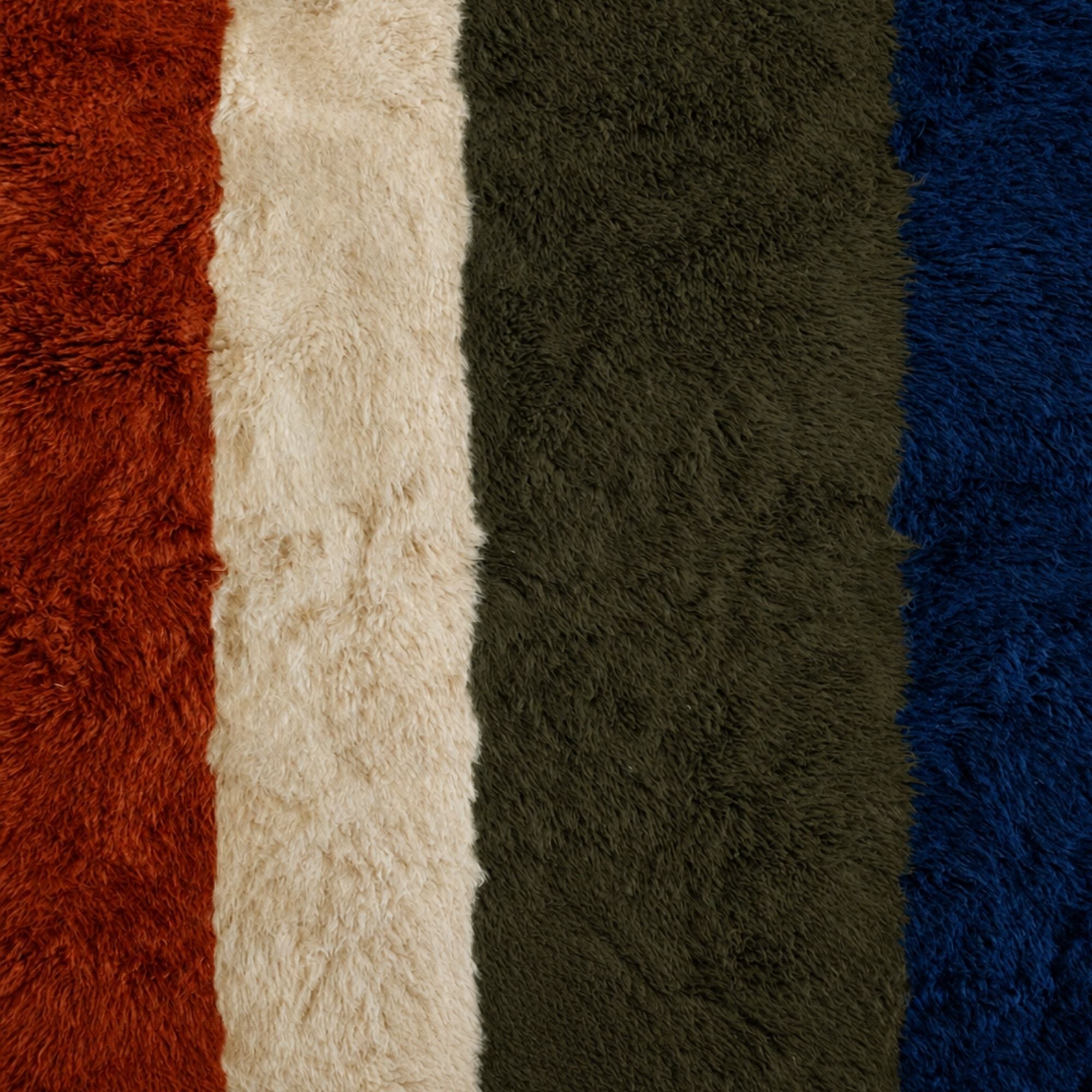 Close-up of Passage handwoven Moroccan wool rug showing blue, olive, ivory and terracotta high-pile texture