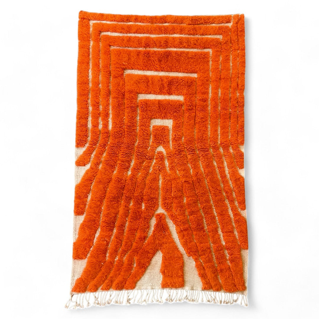 Custom-made Sahara Symphony Moroccan rug in vibrant orange with a textured design revealing a white base