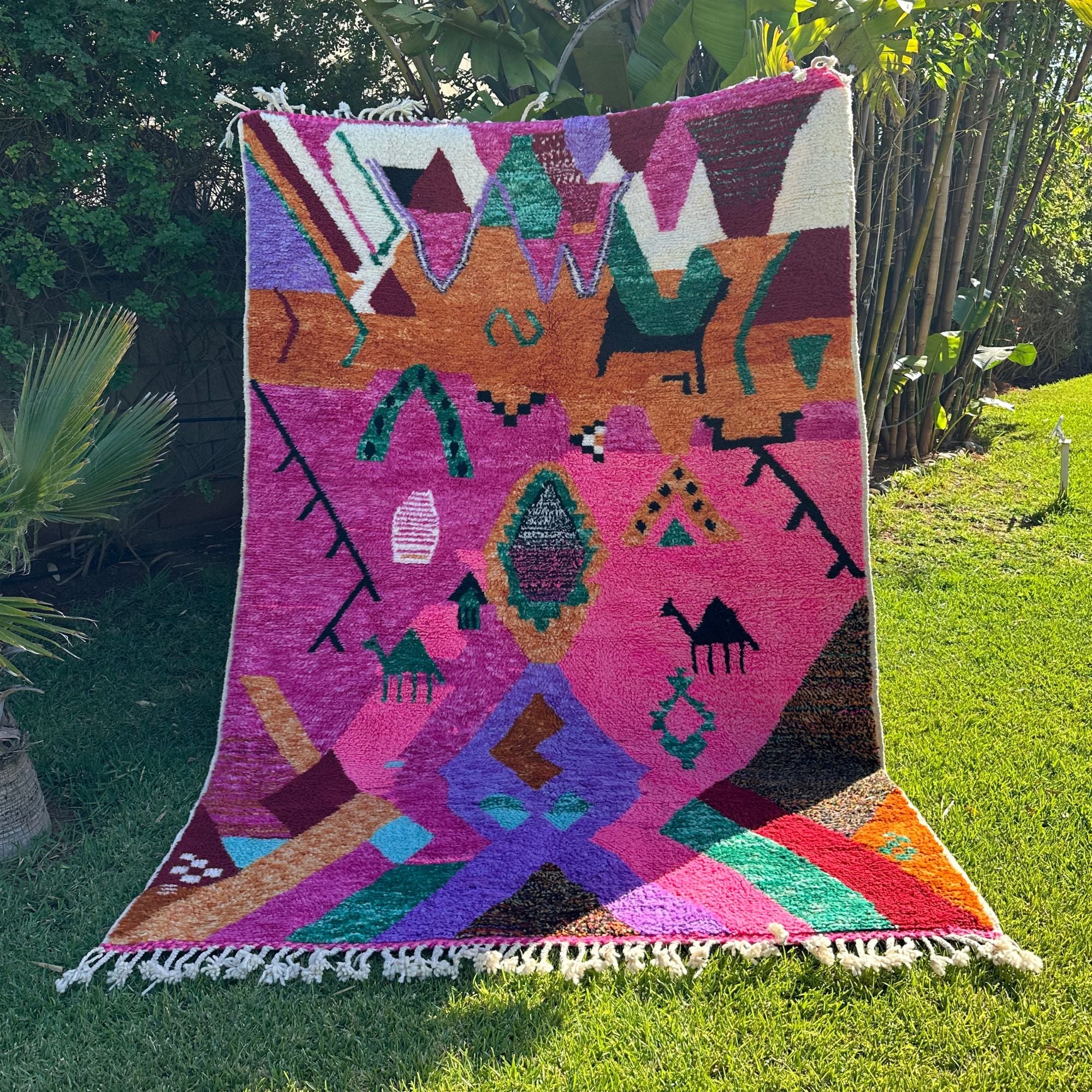 Desert Dance handmade wool rug in stock with a pink base and multicolor design, featuring Berber women's secret language, handwoven by Berber artisans