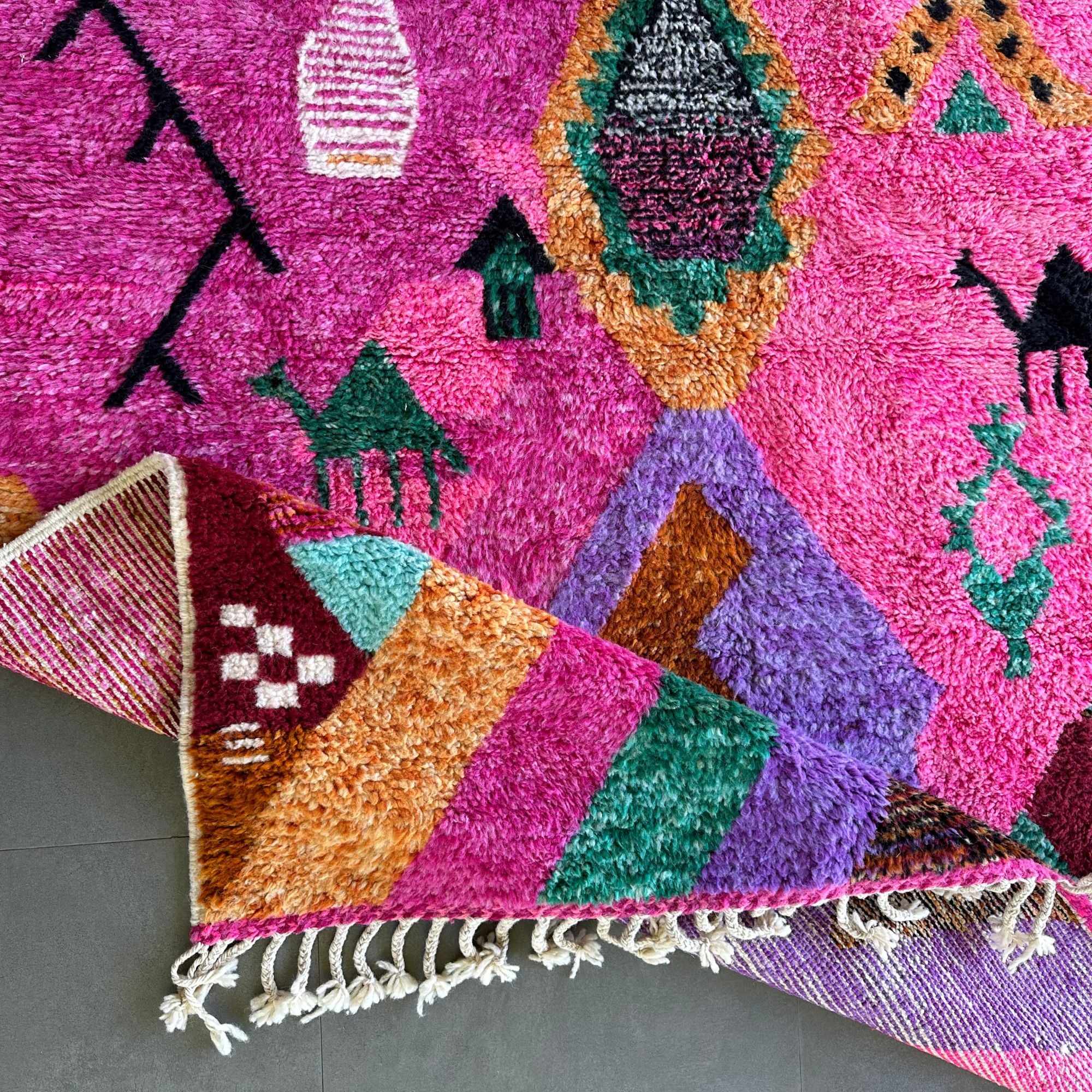 Desert Dance handmade wool rug in stock with a pink base and multicolor design, featuring Berber women's secret language, handwoven by Berber artisans