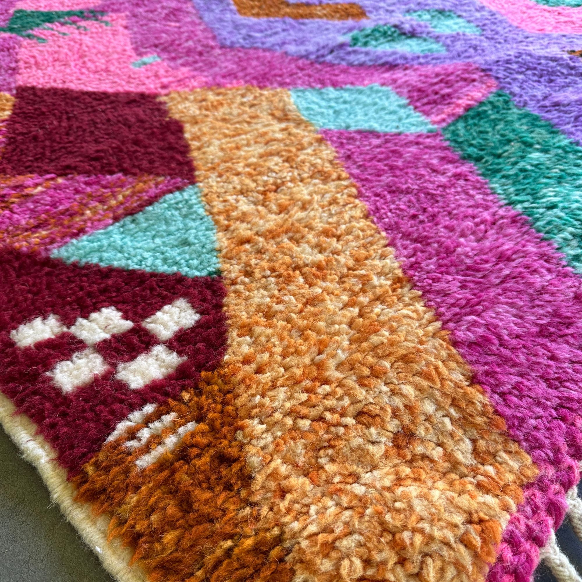 Desert Dance handmade wool rug in stock with a pink base and multicolor design, featuring Berber women's secret language, handwoven by Berber artisans
