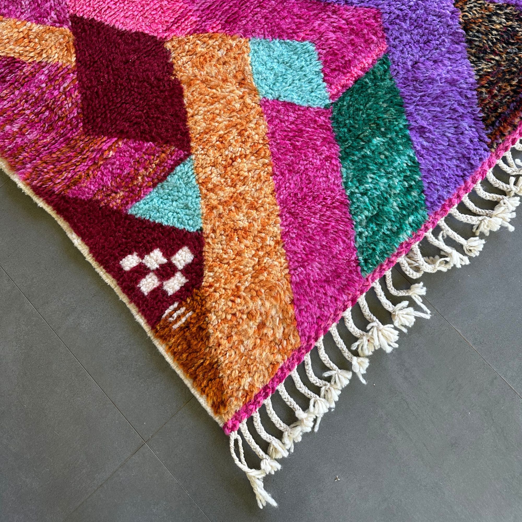 Desert Dance handmade wool rug in stock with a pink base and multicolor design, featuring Berber women's secret language, handwoven by Berber artisans