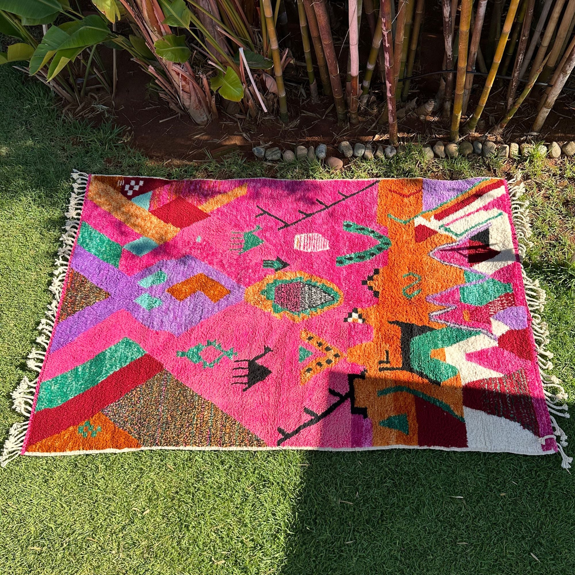 Desert Dance handmade wool rug in stock with a pink base and multicolor design, featuring Berber women's secret language, handwoven by Berber artisans