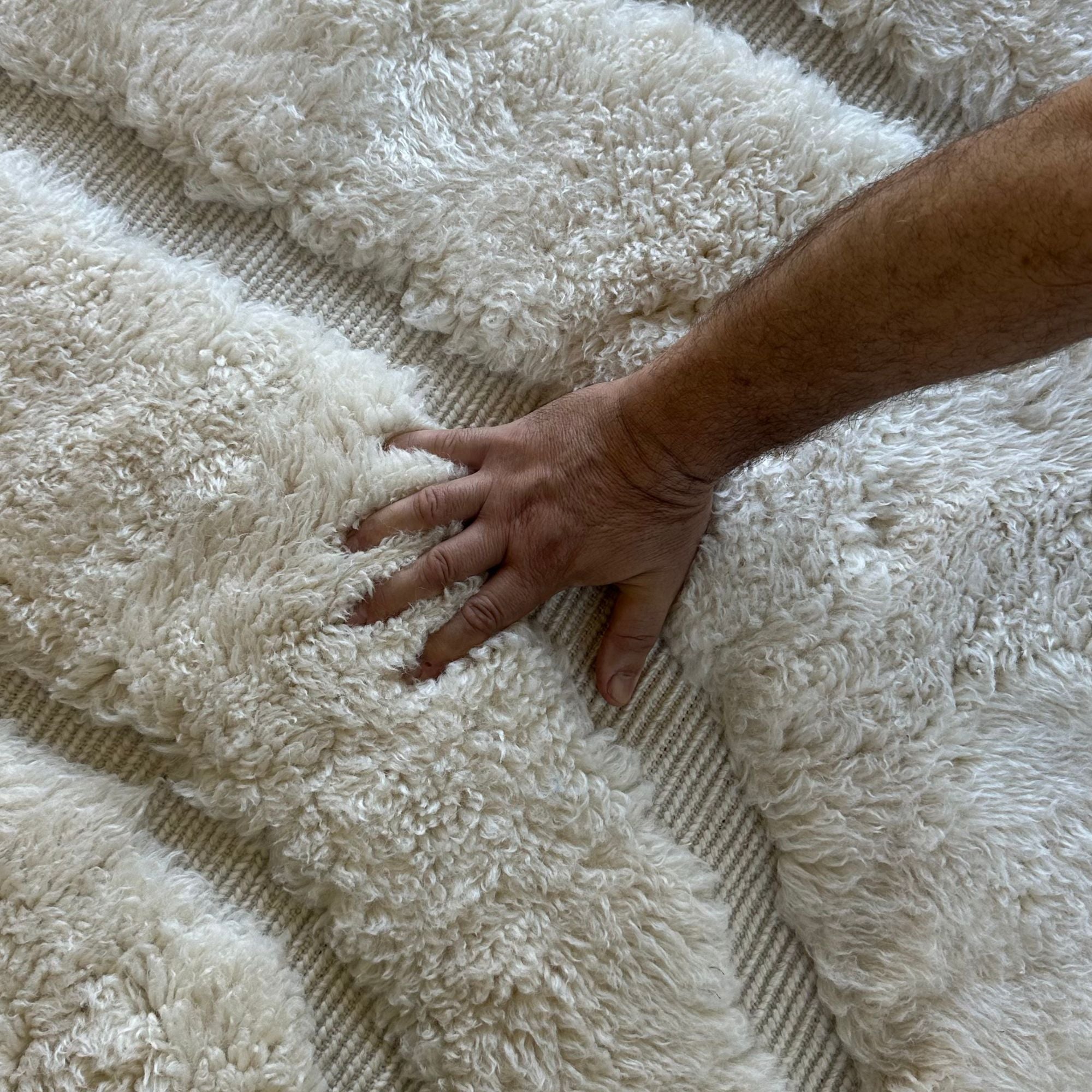 esert Serenity, a handcrafted white Moroccan rug with subtle textured patterns, made of 100% natural wool, displayed against a neutral backdrop to highlight its minimalist and elegant design