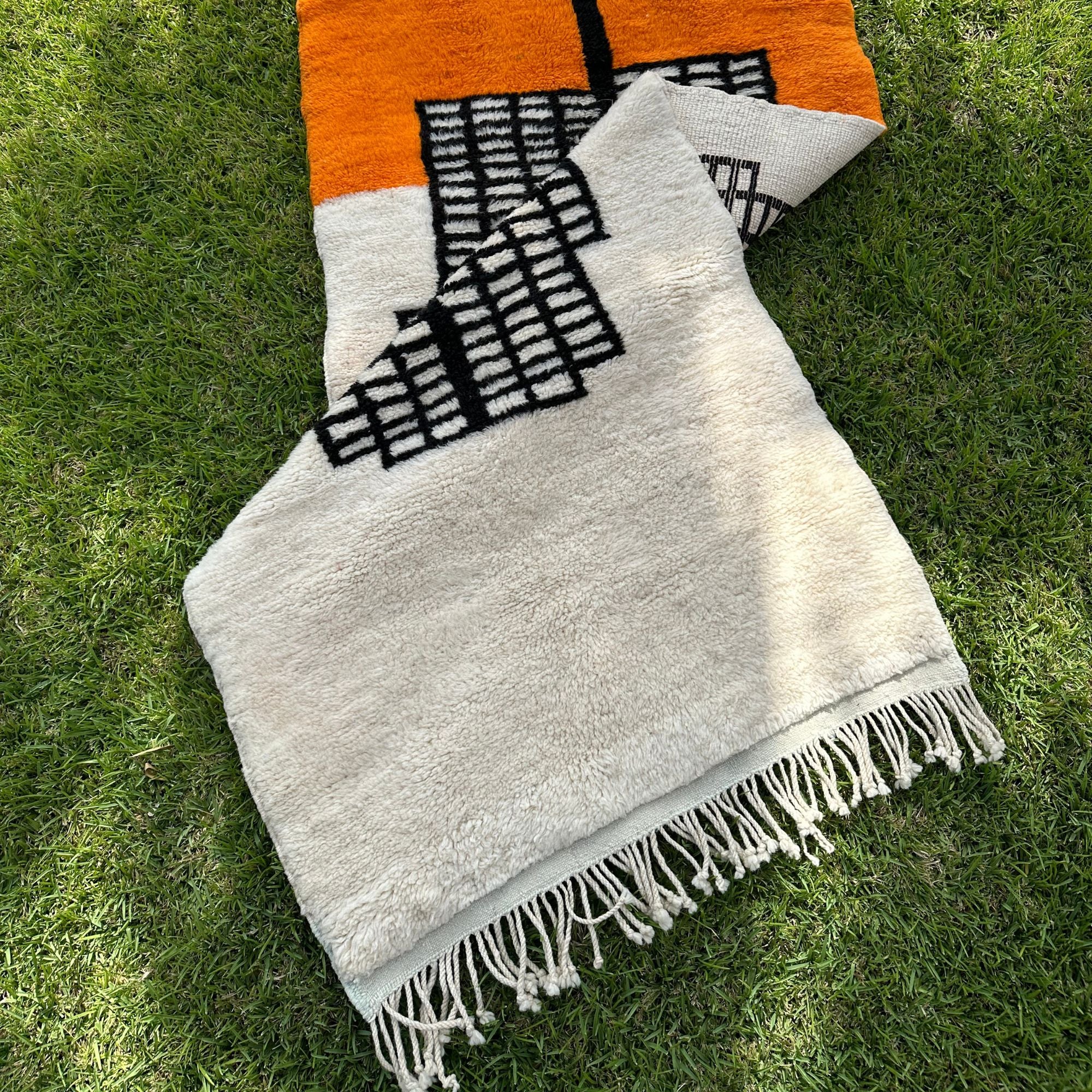 Enchanted Echo 3 foot wide runner rug with an orange and white color scheme and a tribal Berber design in the middle, handwoven by Berber artisans
