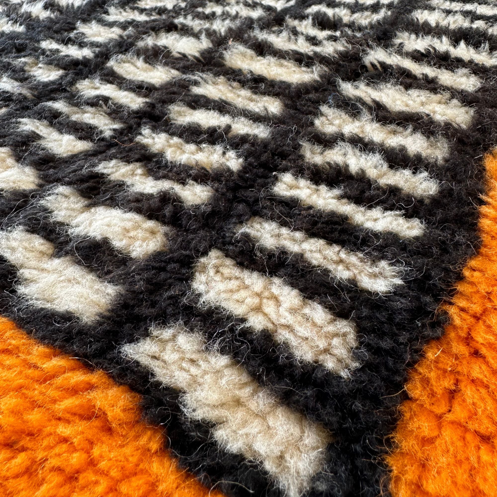 Enchanted Echo 3 foot wide runner rug with an orange and white color scheme and a tribal Berber design in the middle, handwoven by Berber artisans