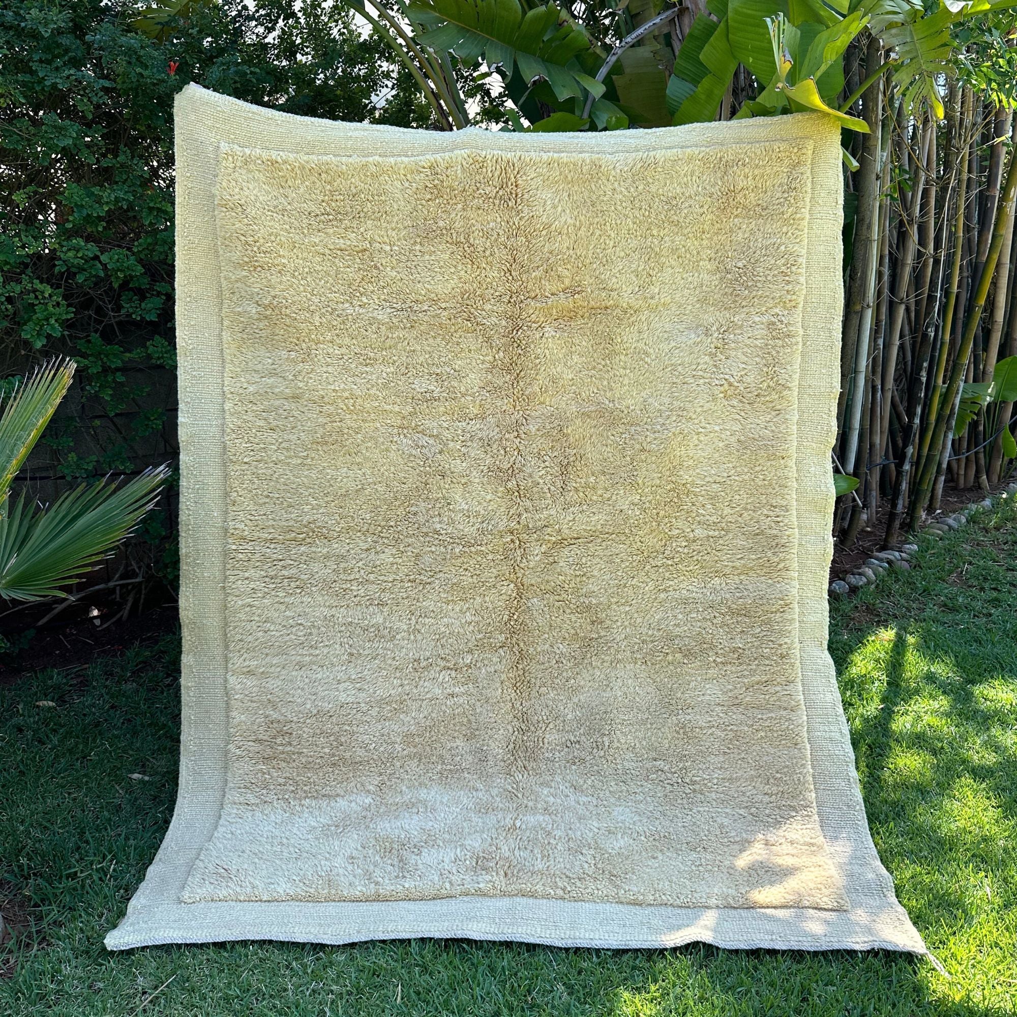 Ethereal Elegance handmade wool rug with an immaculate creme color, long pile in the center, and flat edges, handwoven by Berber artisans