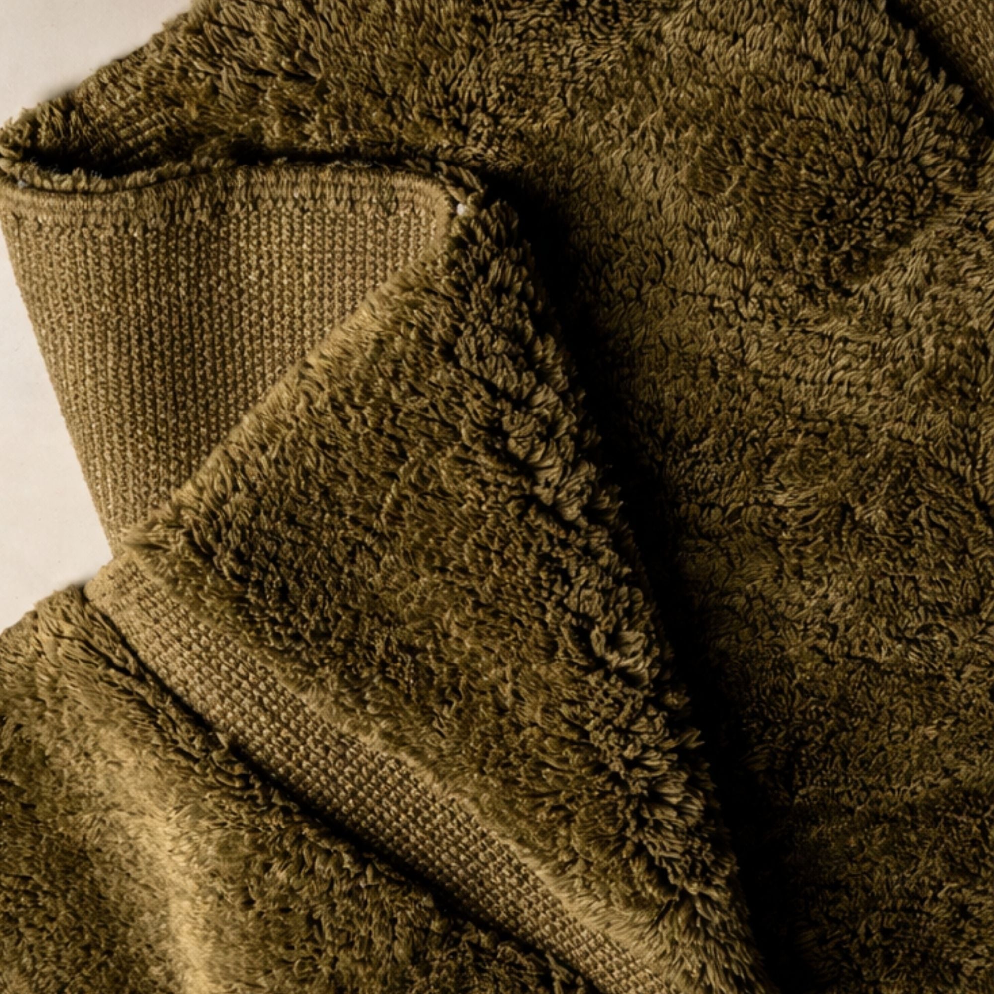 Folded corner of Contour No. 01 rug showing contrast between plush wool pile and flat-woven base.