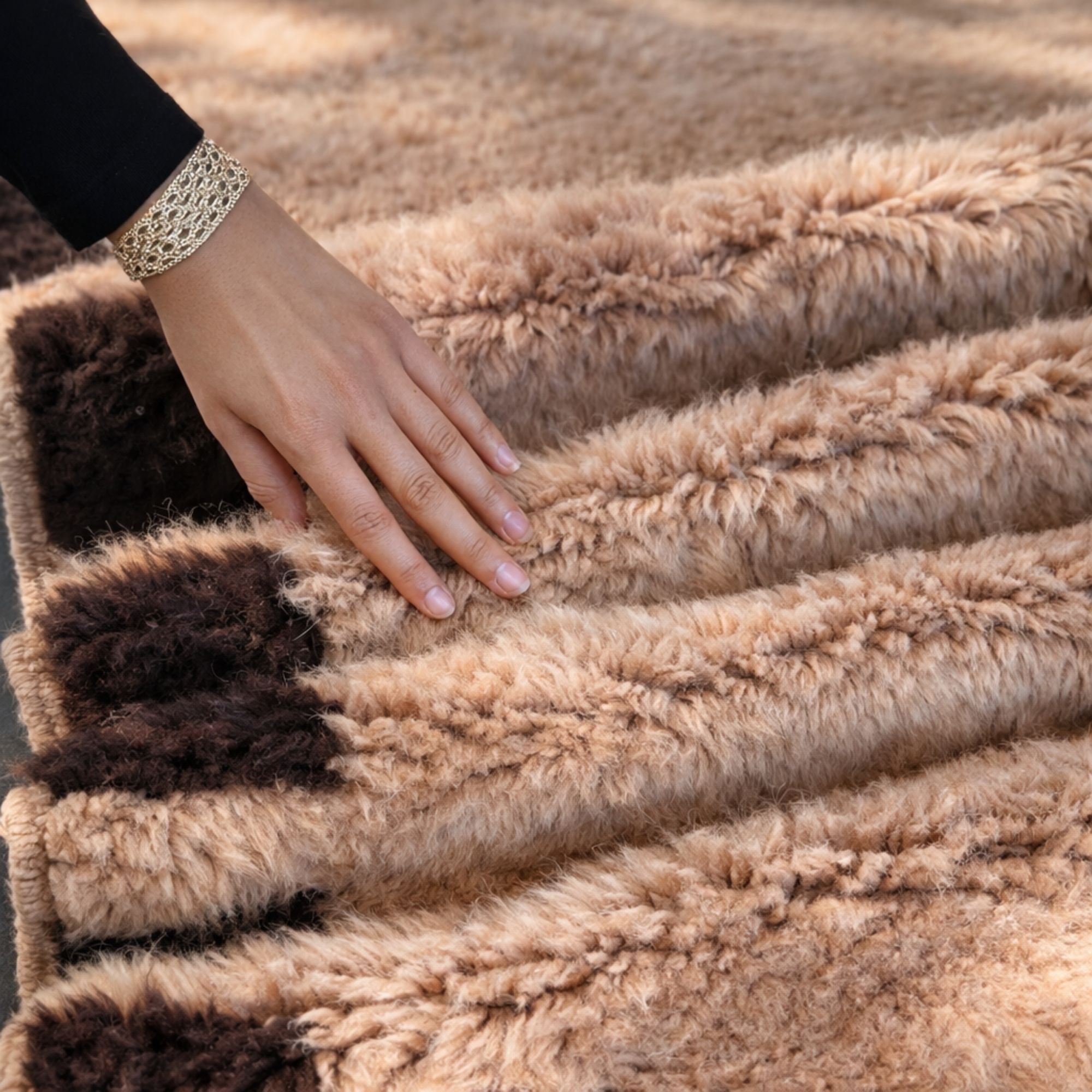 Hand touching the folded Cadence Moroccan wool rug, showcasing the ultra-soft high pile texture, thick handcrafted structure, and black geometric border details in warm ivory tones.