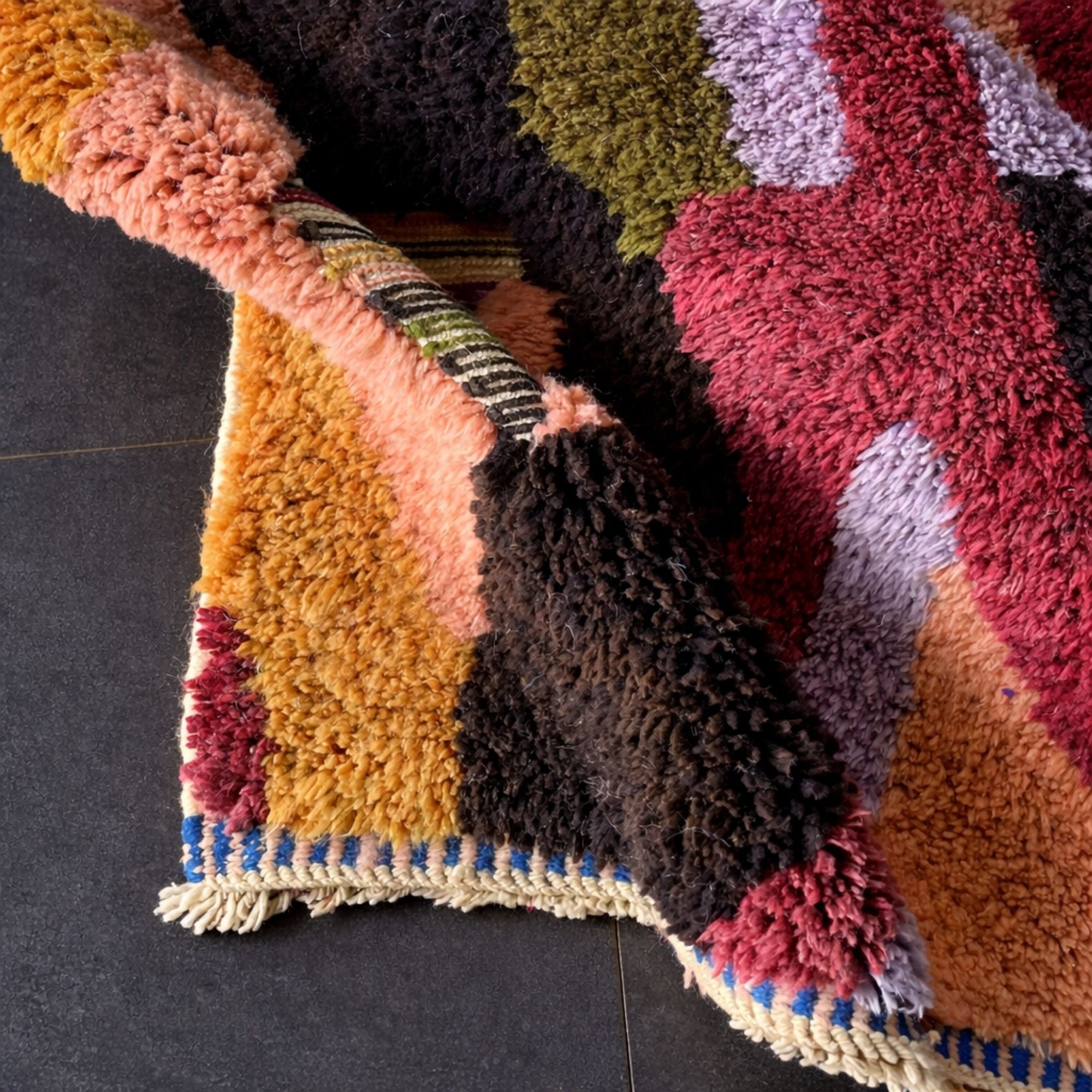 Handwoven Moroccan wool rug, Chorus design, corner detail with fringe and flatwoven striped edge.