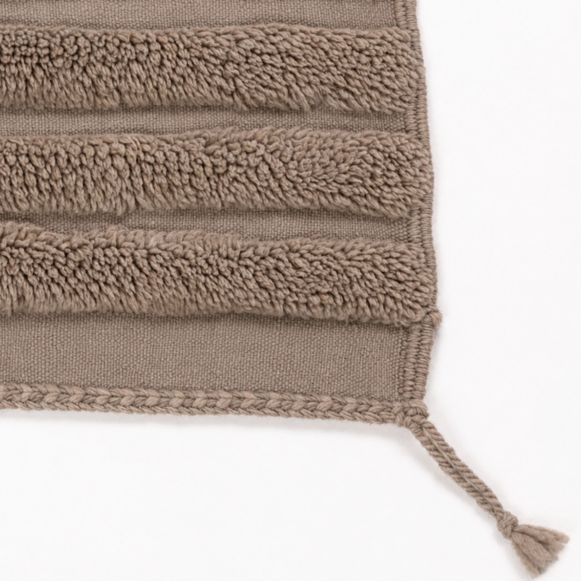 Handwoven Moroccan wool rug detail showing textured raised lines, finished edge and handmade corner tassel