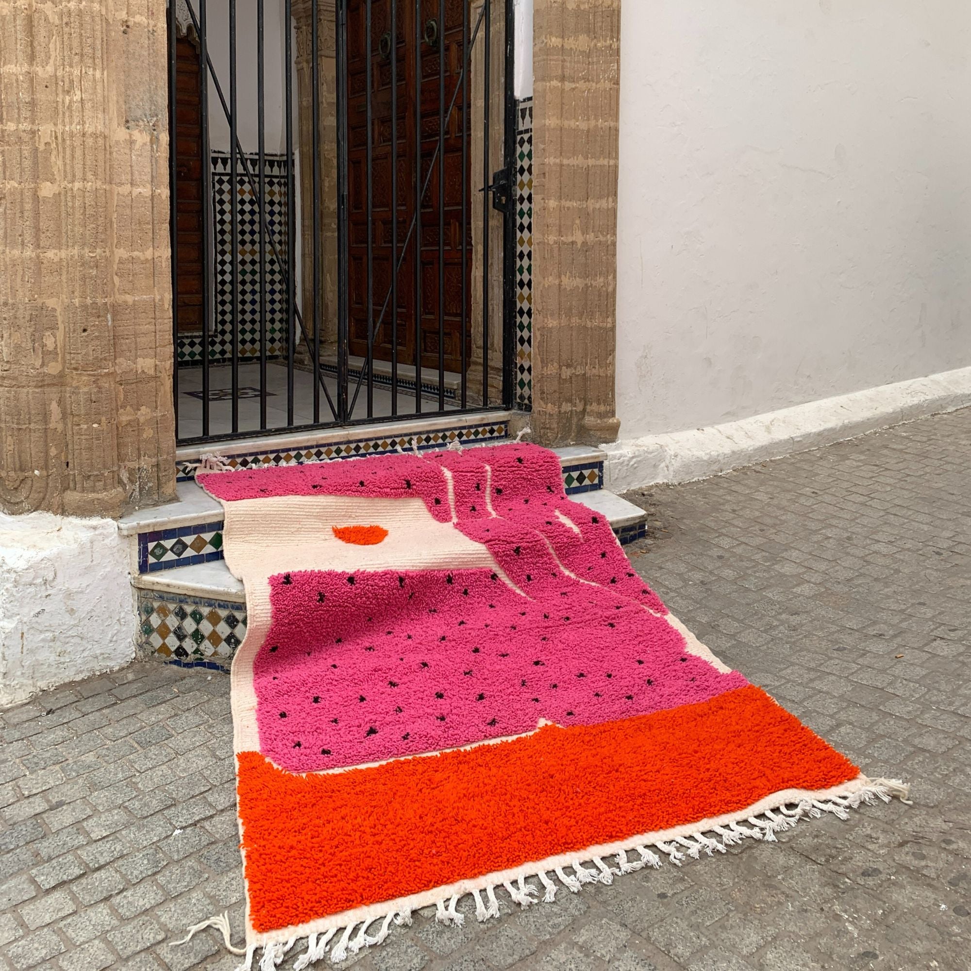 Melon Mirage pink Moroccan rug with a dotted design in black, handwoven by Berber artisans