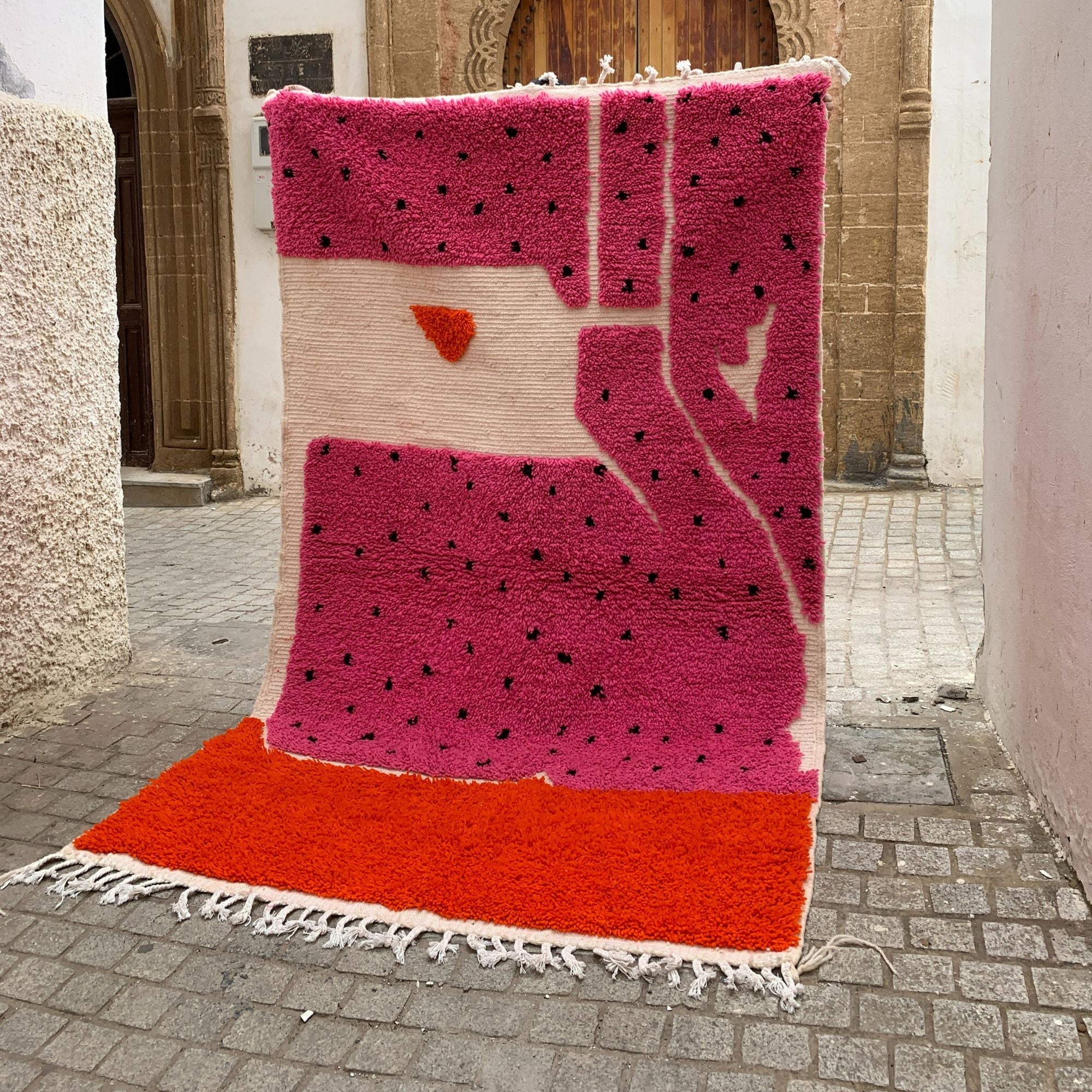 Melon Mirage pink Moroccan rug with a dotted design in black, handwoven by Berber artisans