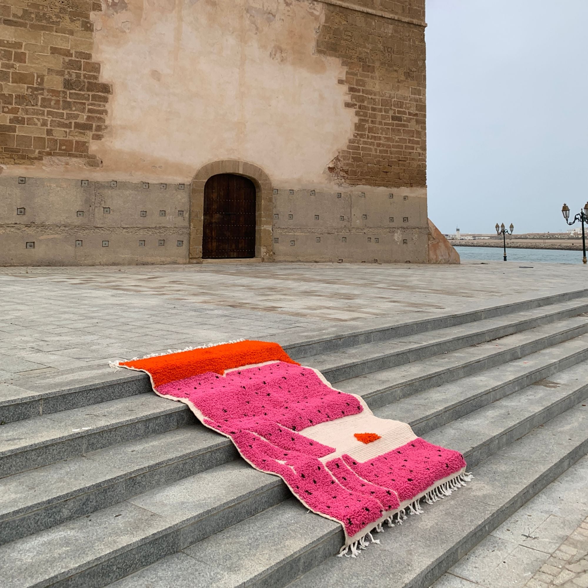 Melon Mirage pink Moroccan rug with black dotted design, handwoven by skilled Berber artisans