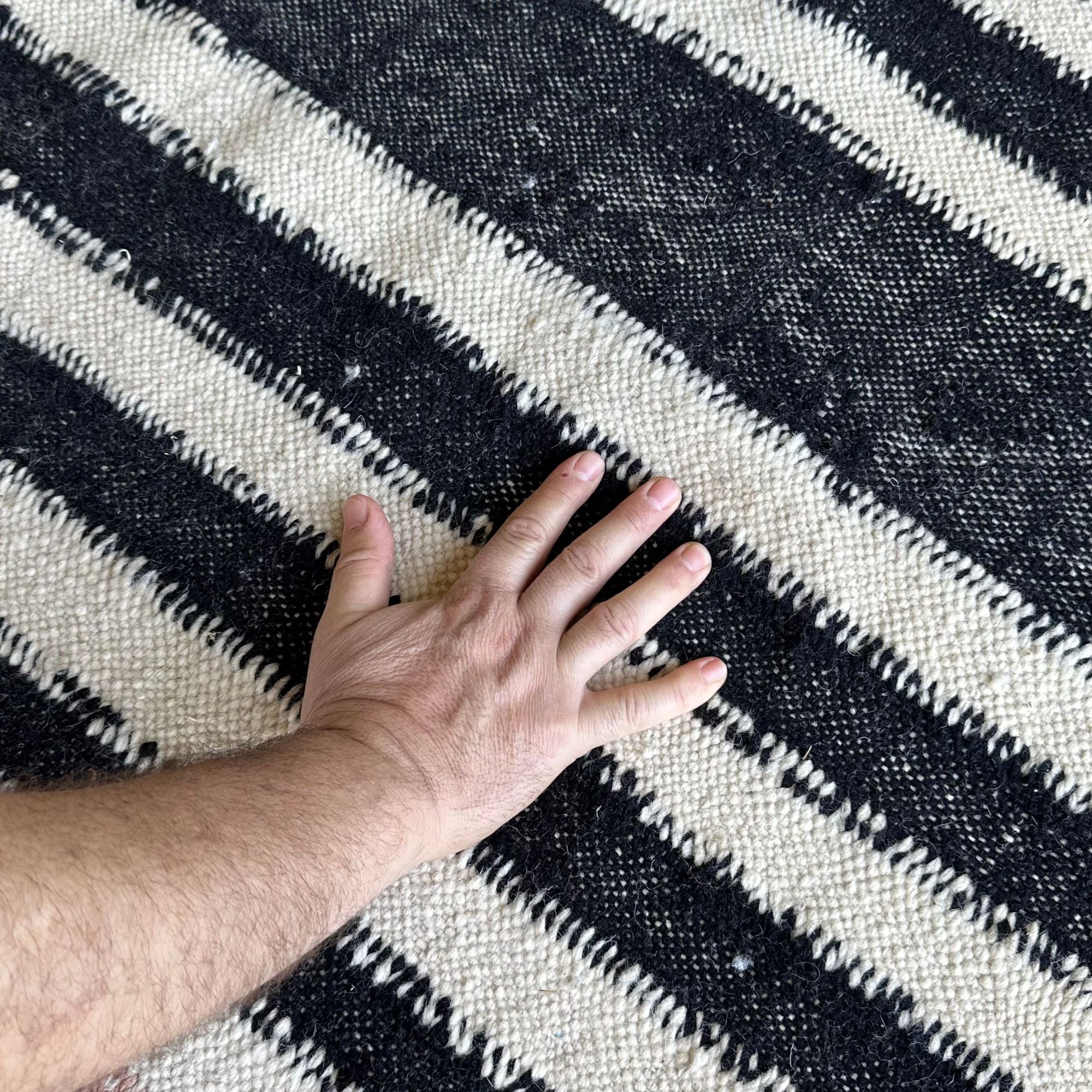 Mystique Beauty flat weave rug with black and brown geometrical patterns on an off-white base.