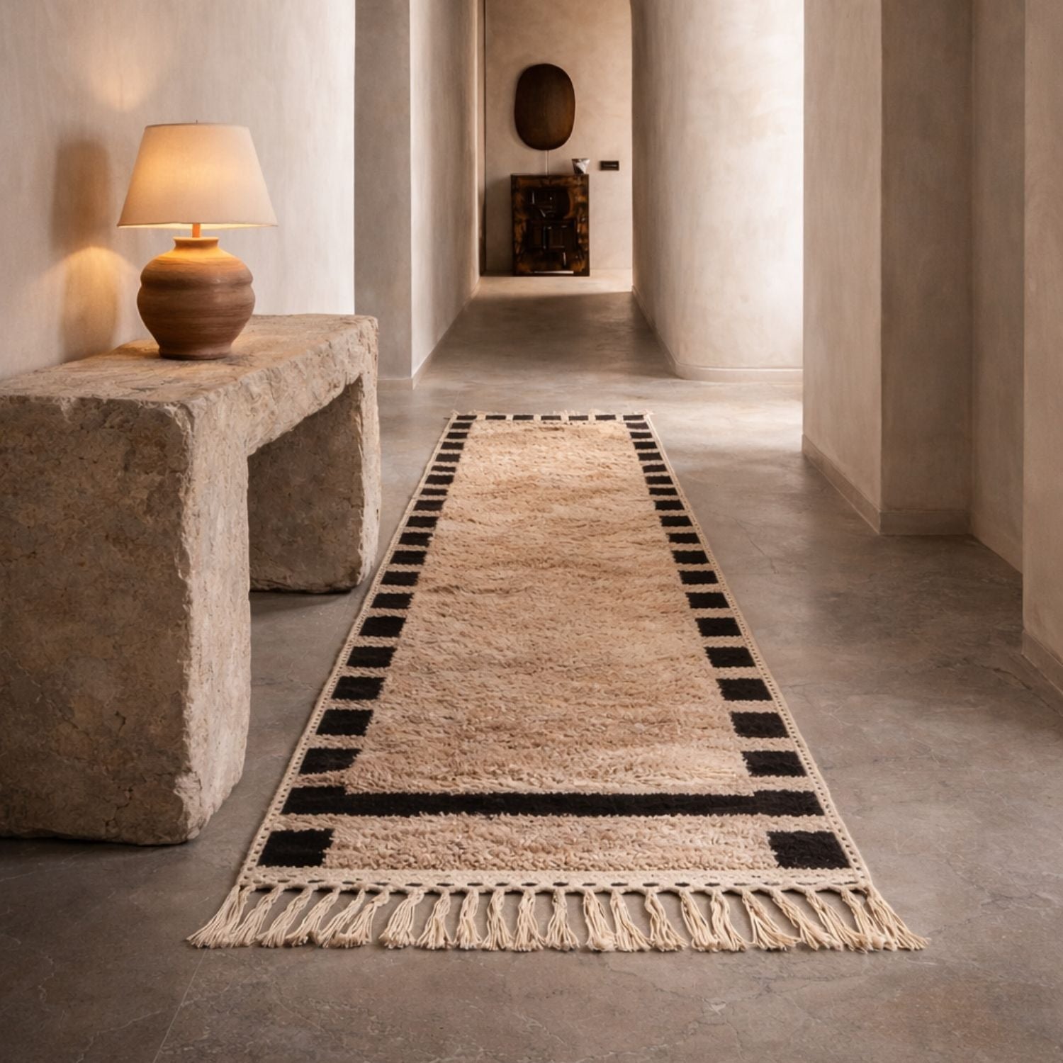 Handmade Moroccan Berber runner rug in cream wool with black border placed in a minimalist hallway interior